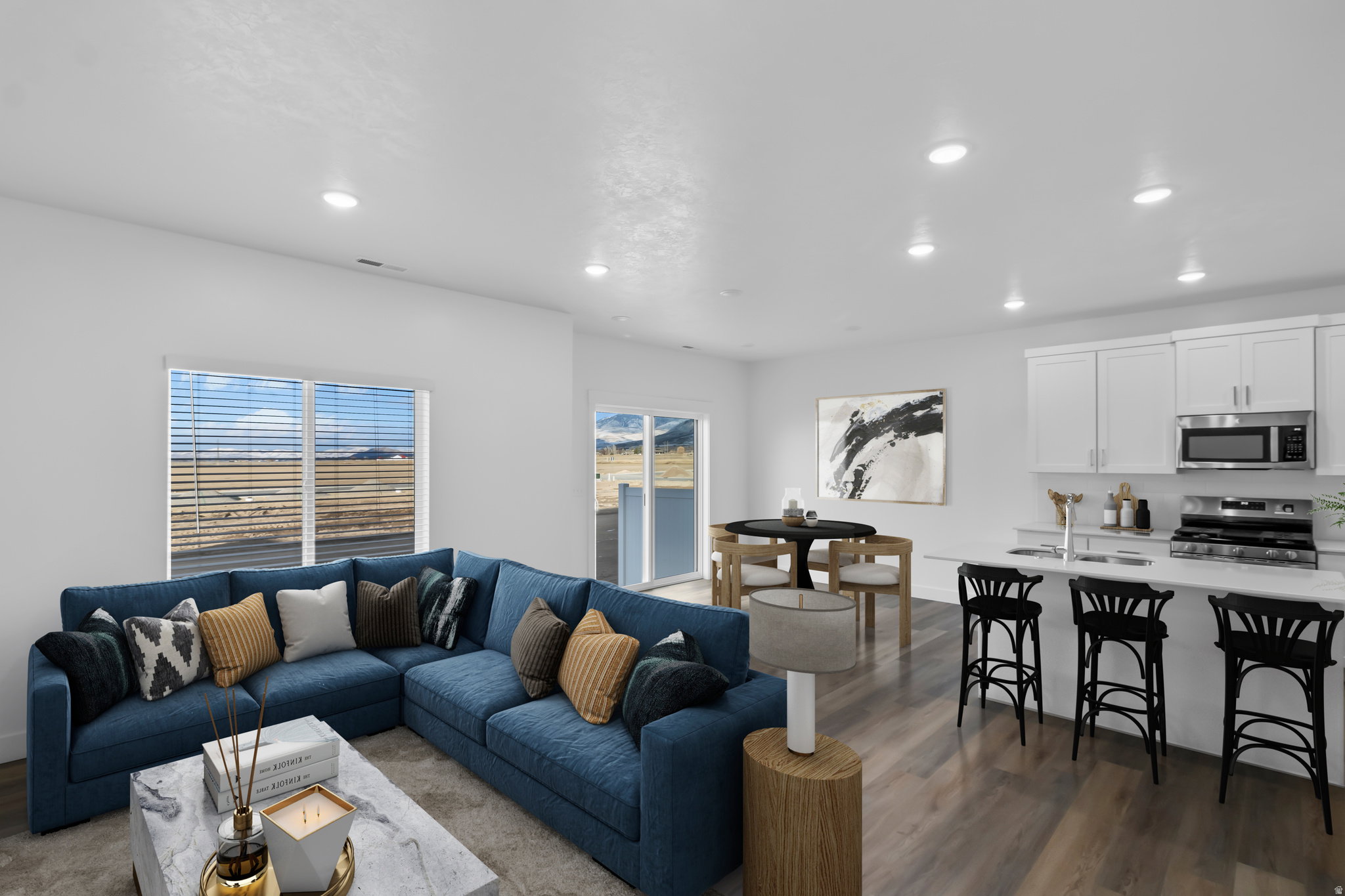 Open-concept living area featuring wood-finish flooring, recessed lighting, and white walls