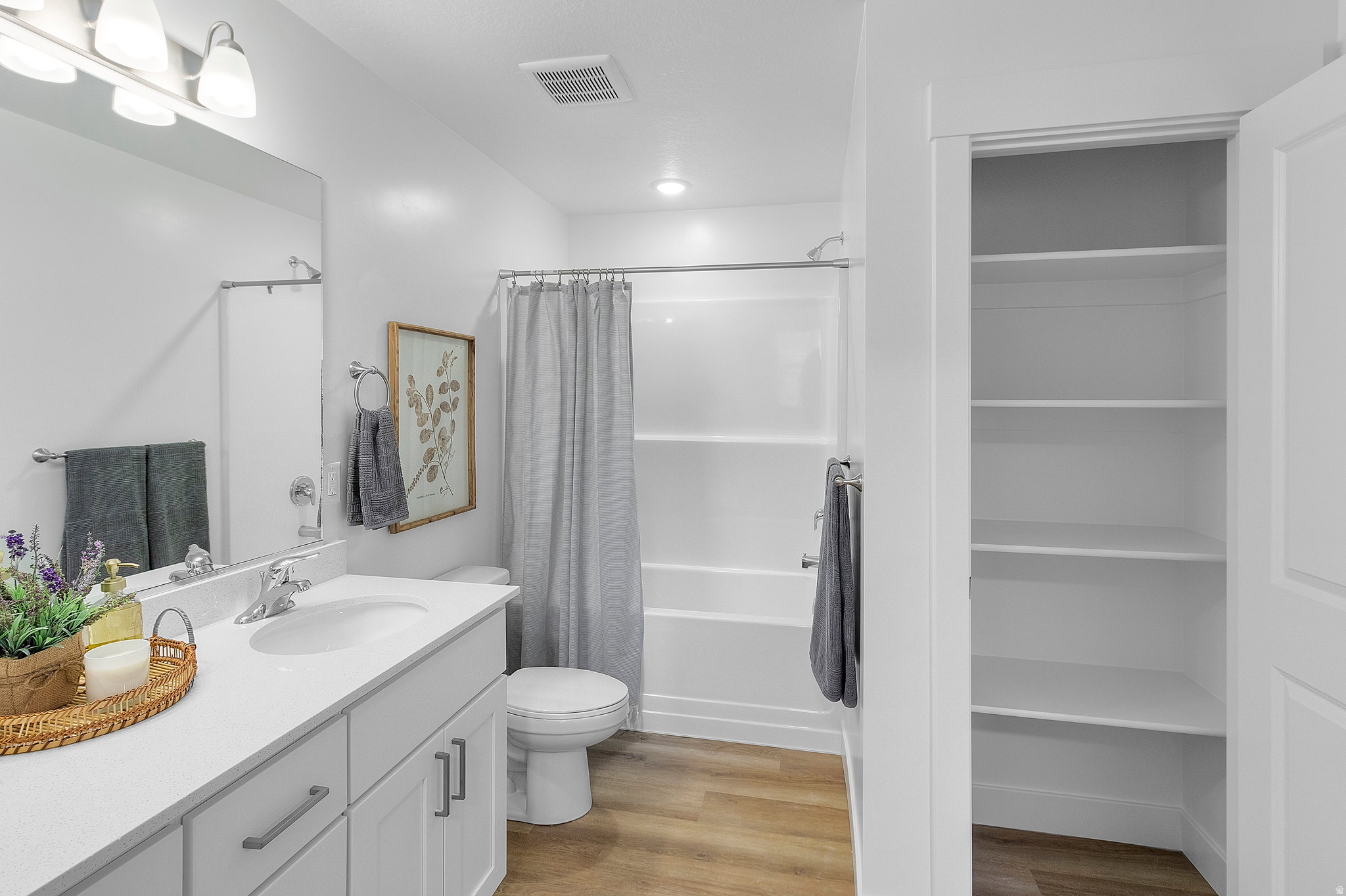 Bathroom featuring a white vanity with integrated sink, chrome faucet, and under-cabinet storage