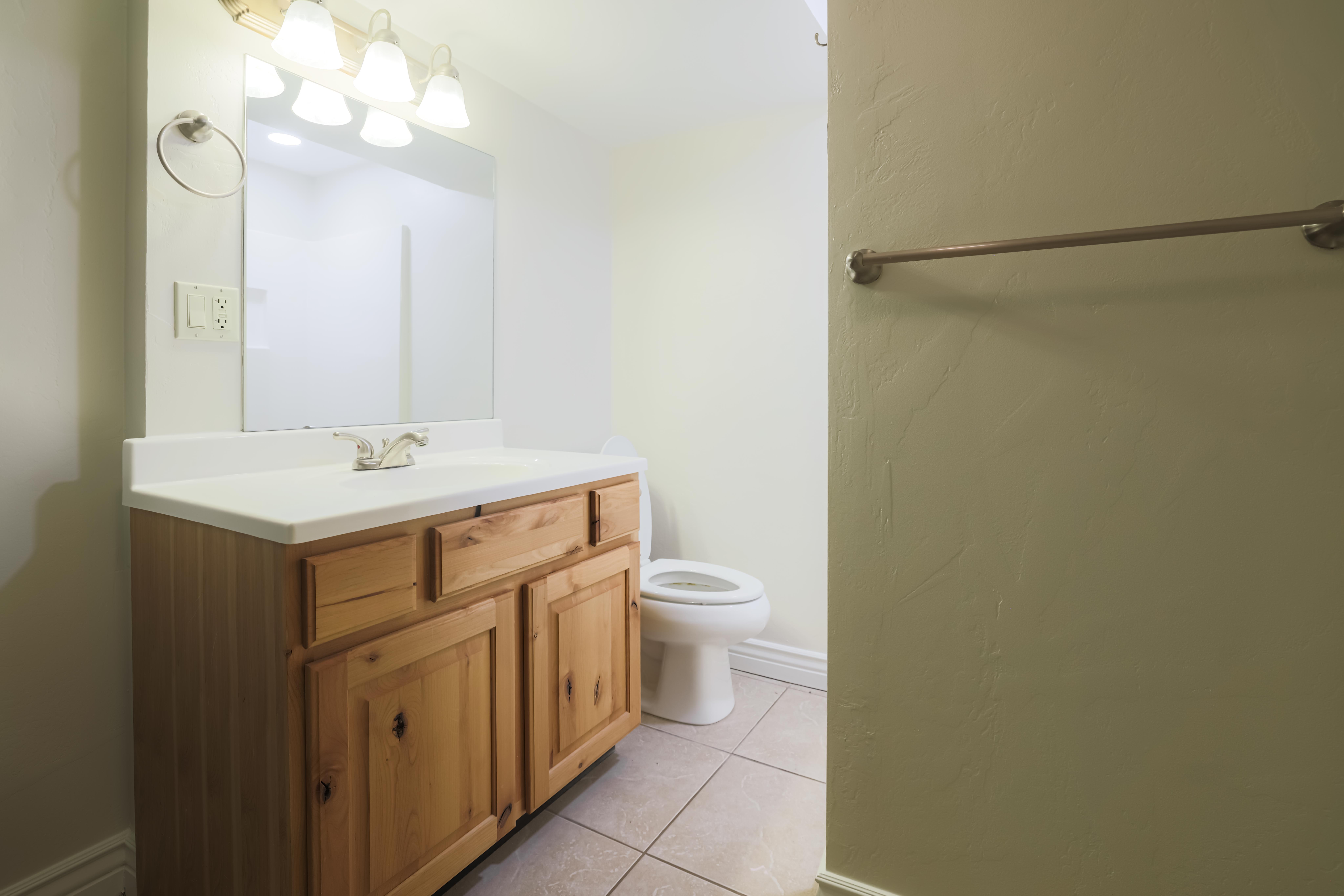 Wood-finish vanity with a white countertop and integrated sink