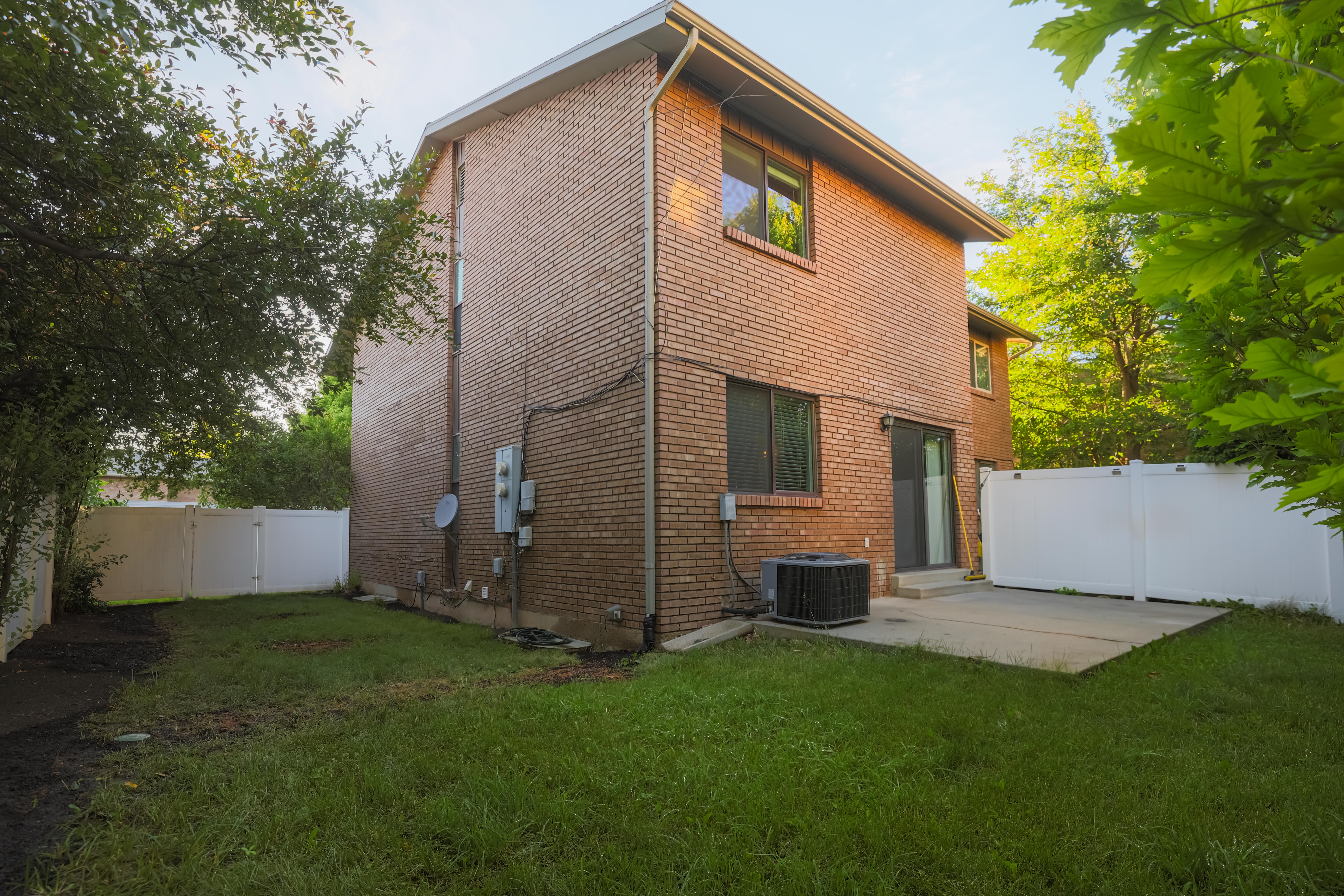 Brick exterior with white vinyl fencing enclosing the property