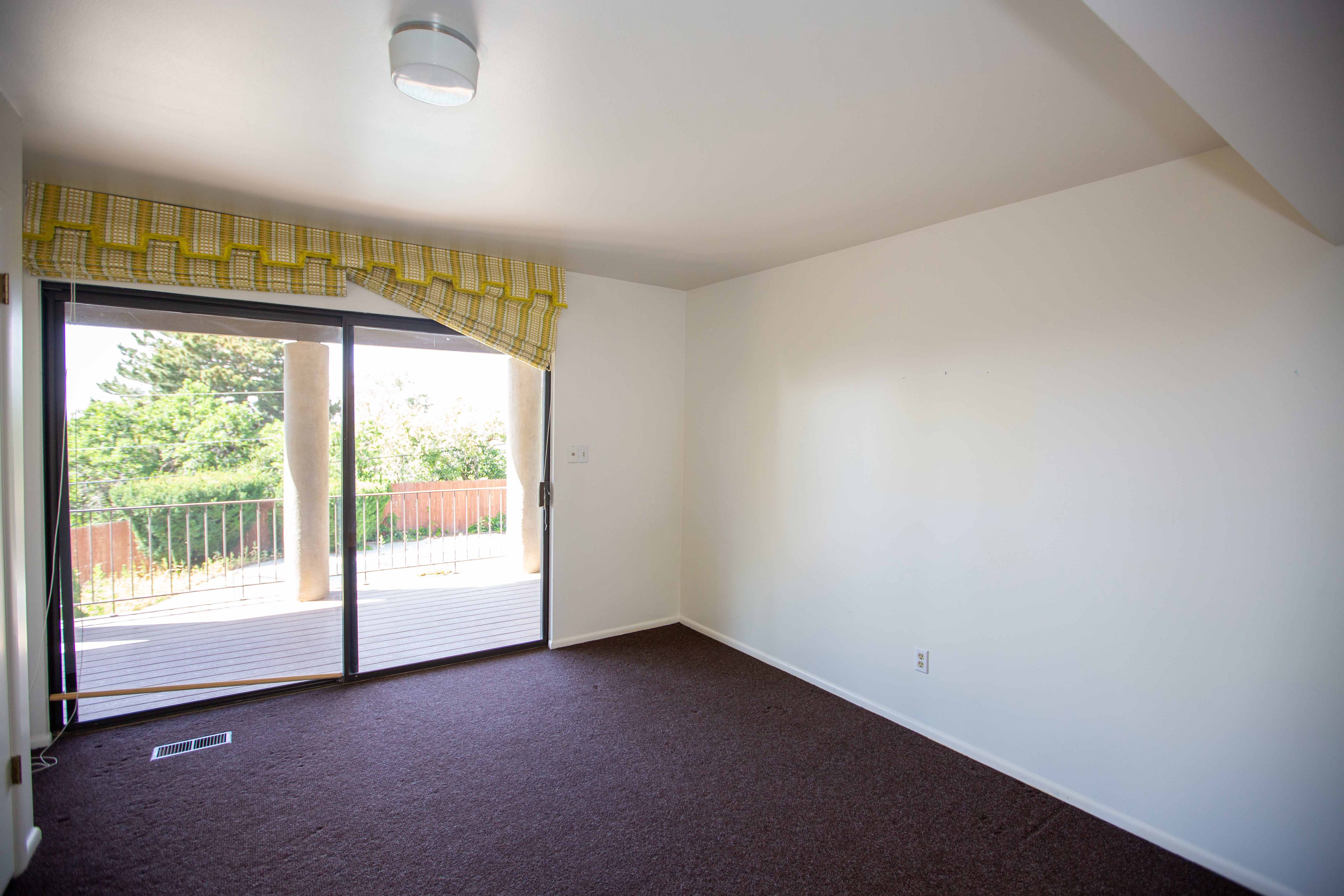 Spacious room featuring broad sliding glass doors opening to an exterior wooden deck