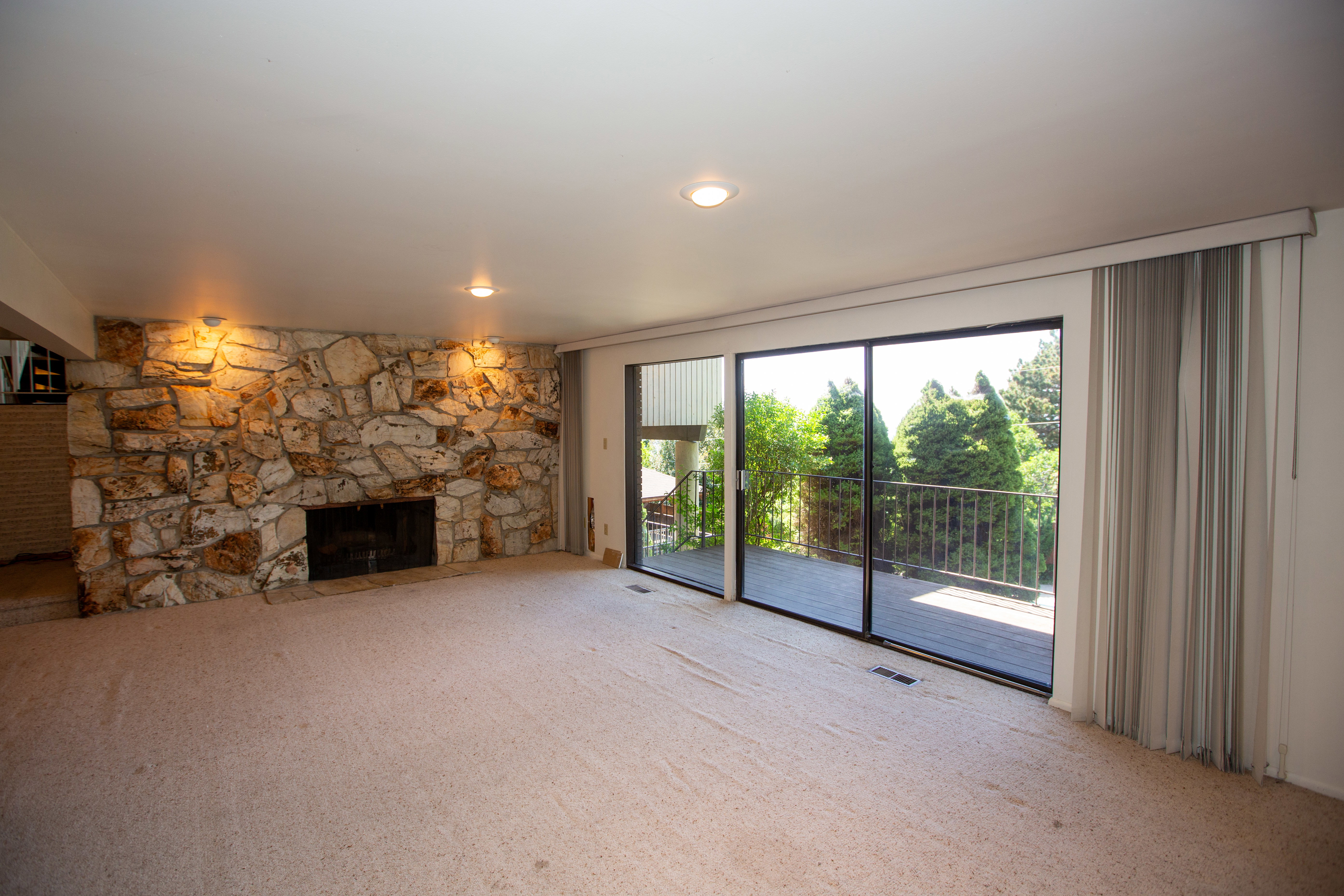 Expansive living area with a full-height stone fireplace and hearth