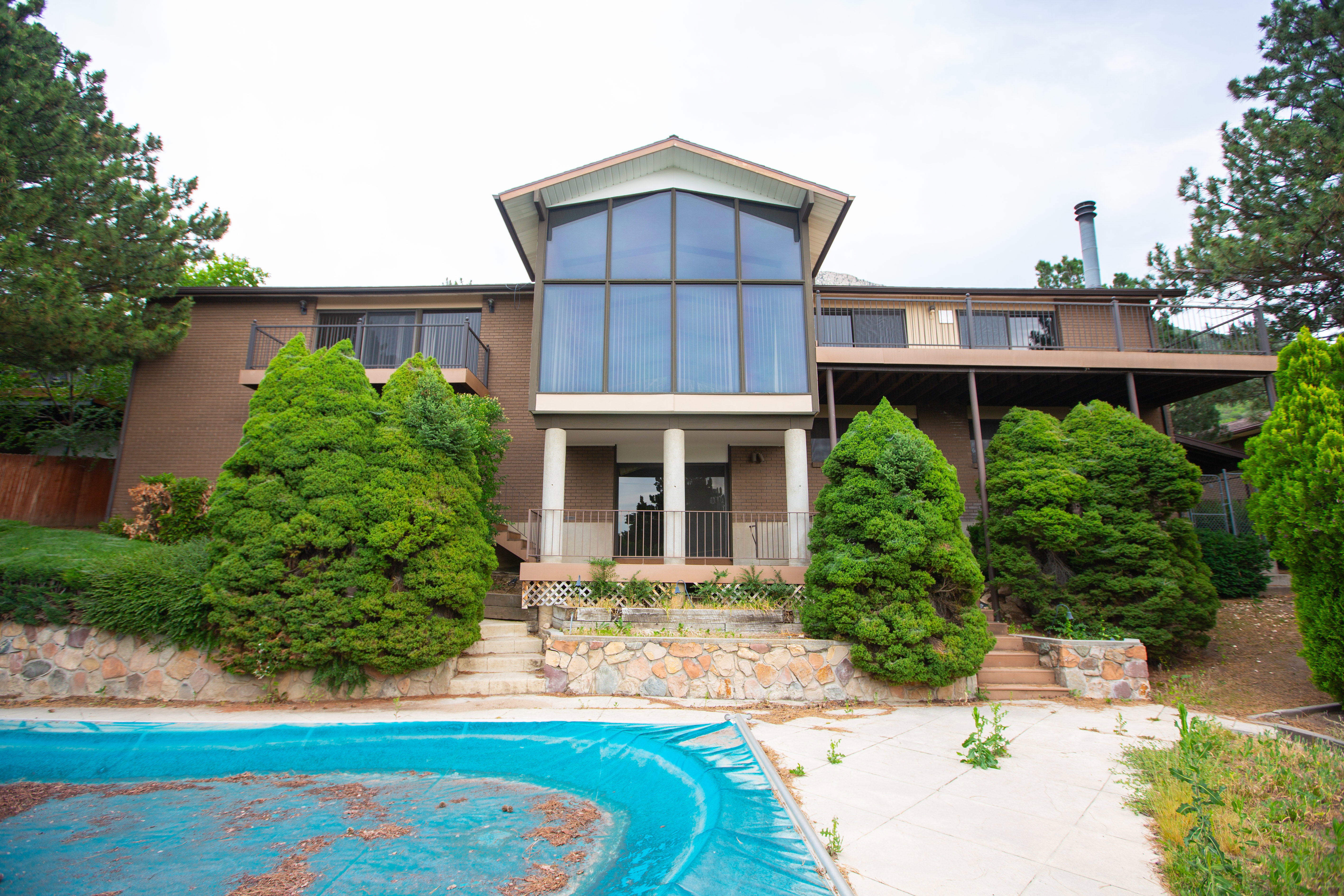 Multi-level residence featuring a brown brick exterior with extensive glass paneling
