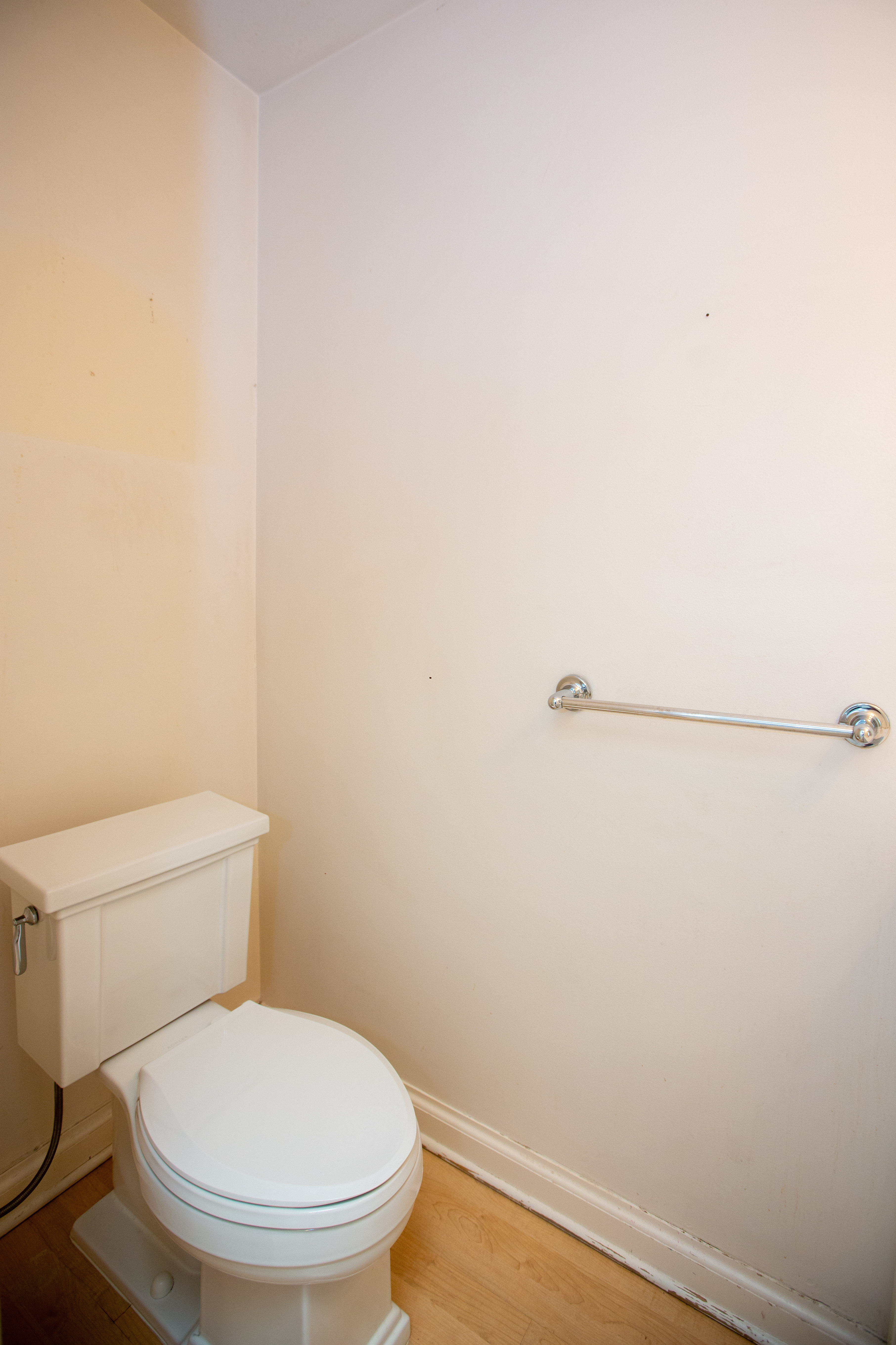 Half bath, wood-finish flooring, and a chrome towel bar