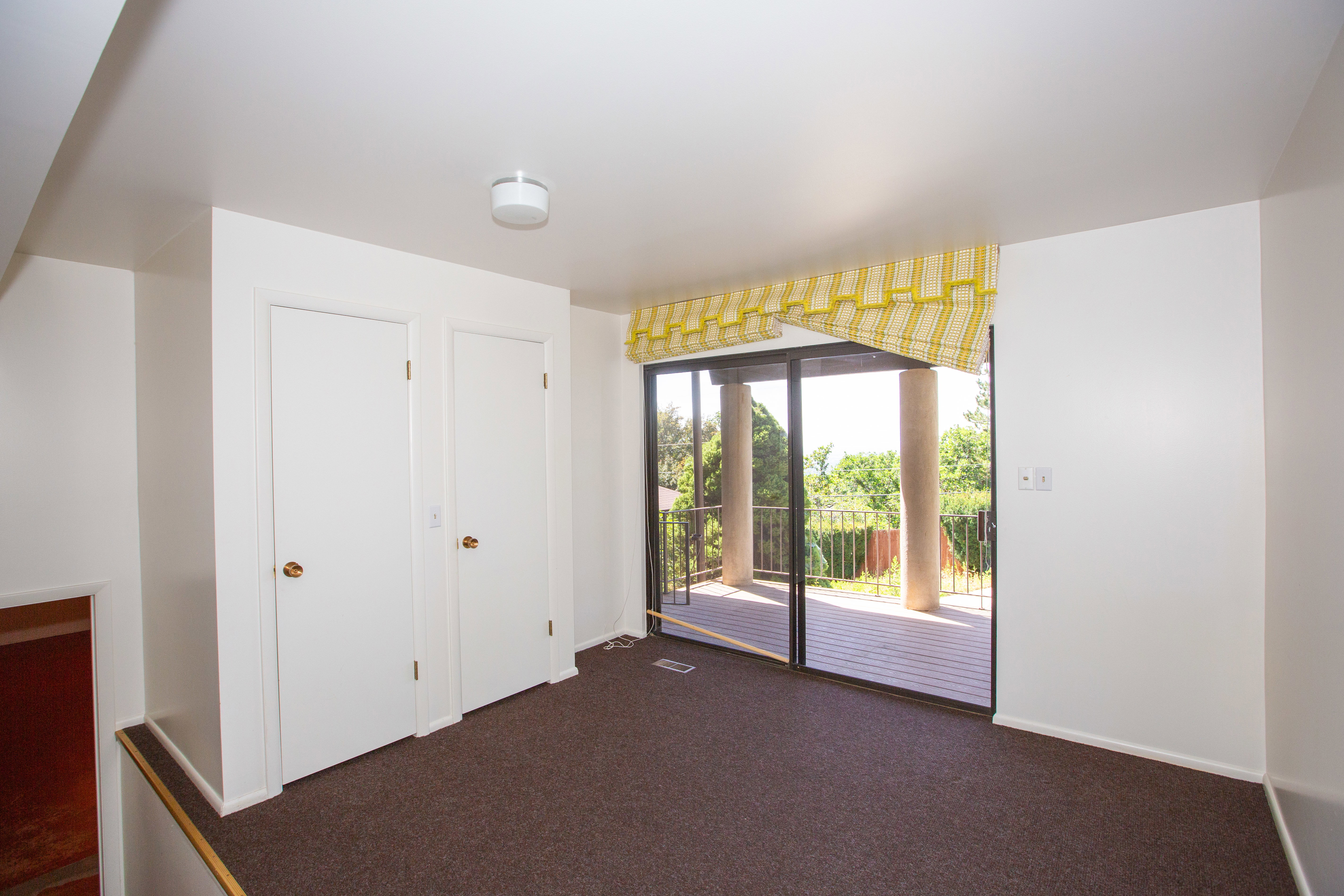 Office/Den with sliding glass doors opening to an outdoor deck with columnar supports and a metal railing