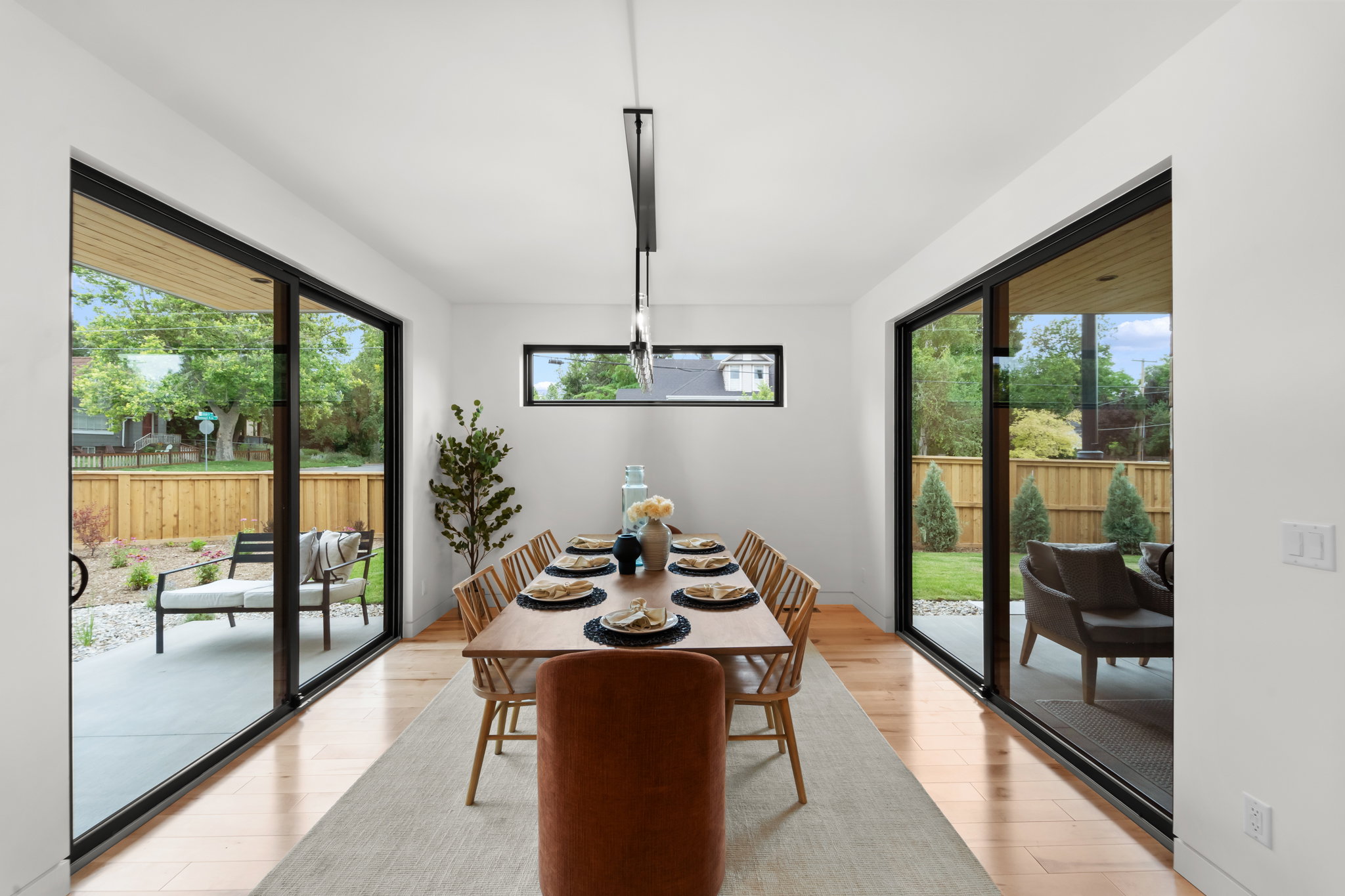 Open-concept dining area featuring light wood-finish flooring and a contemporary linear chandelier