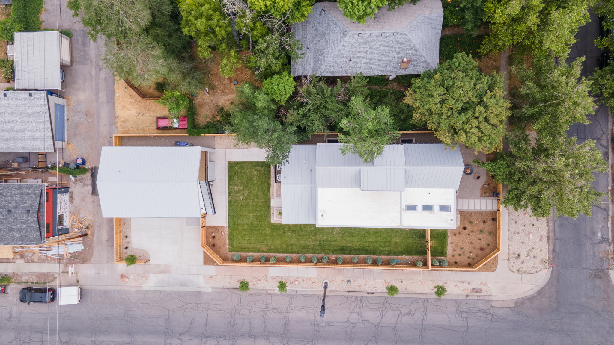 Aerial perspective showcasing a modern residence with a metal roof and multiple skylights