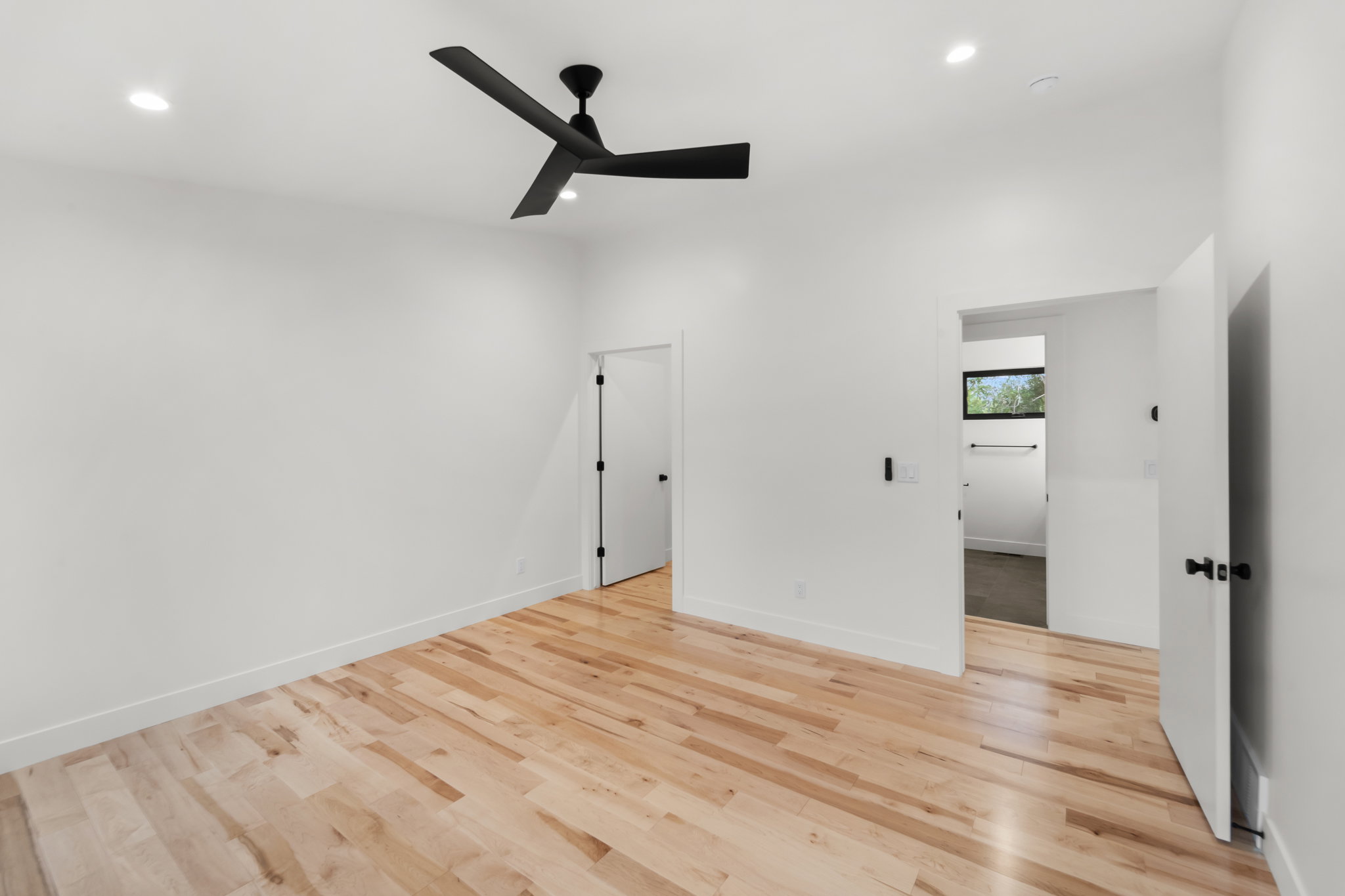 Bedroom featuring natural wood-finish flooring, recessed lighting, and a modern ceiling fan