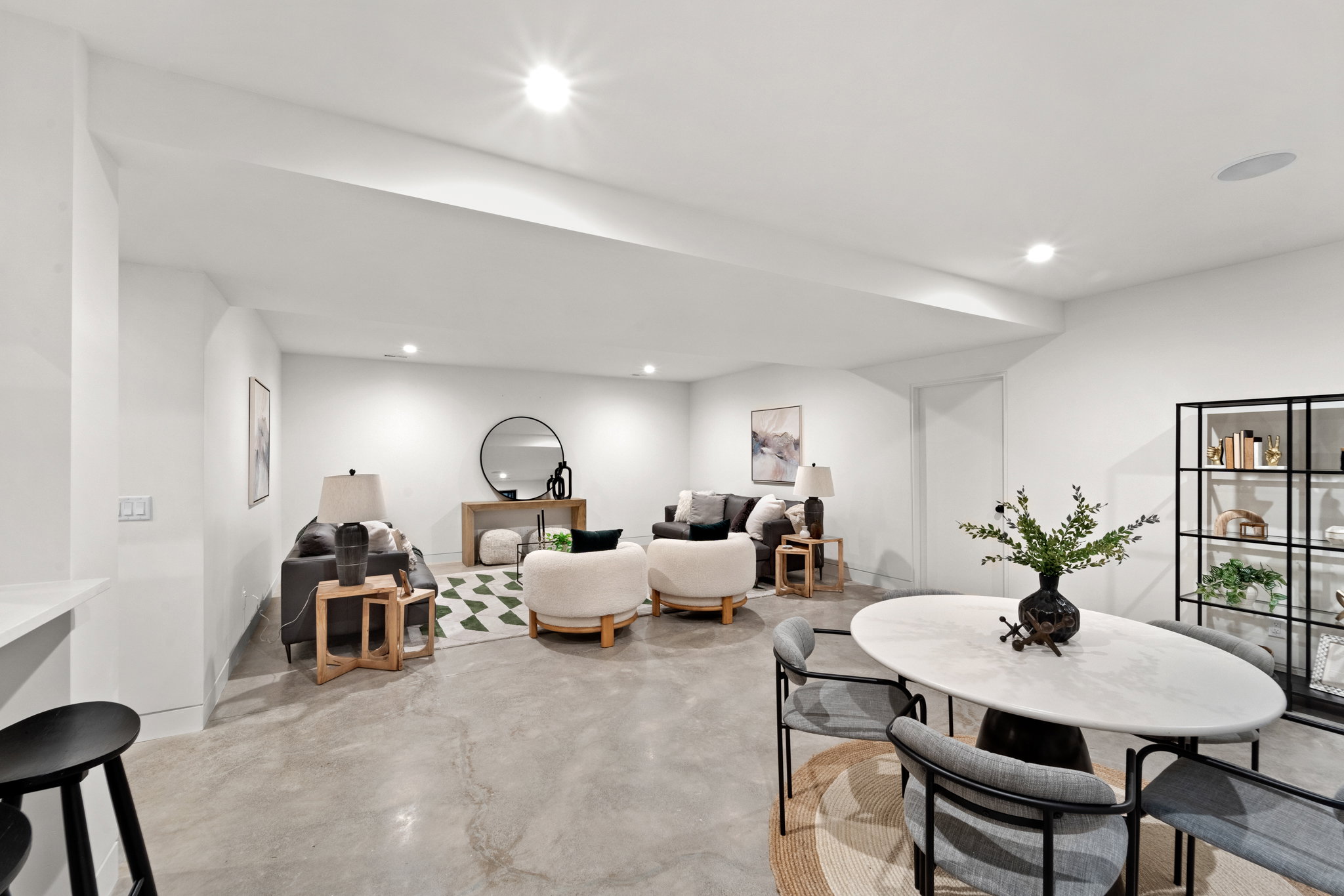 Open-concept living space featuring concrete flooring, recessed lighting, and a white countertop bar