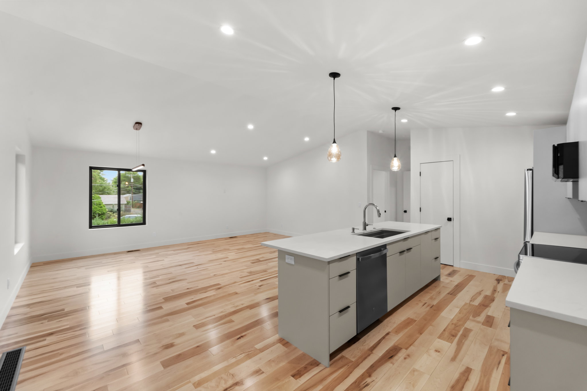 Open-concept living space with light wood-finish flooring