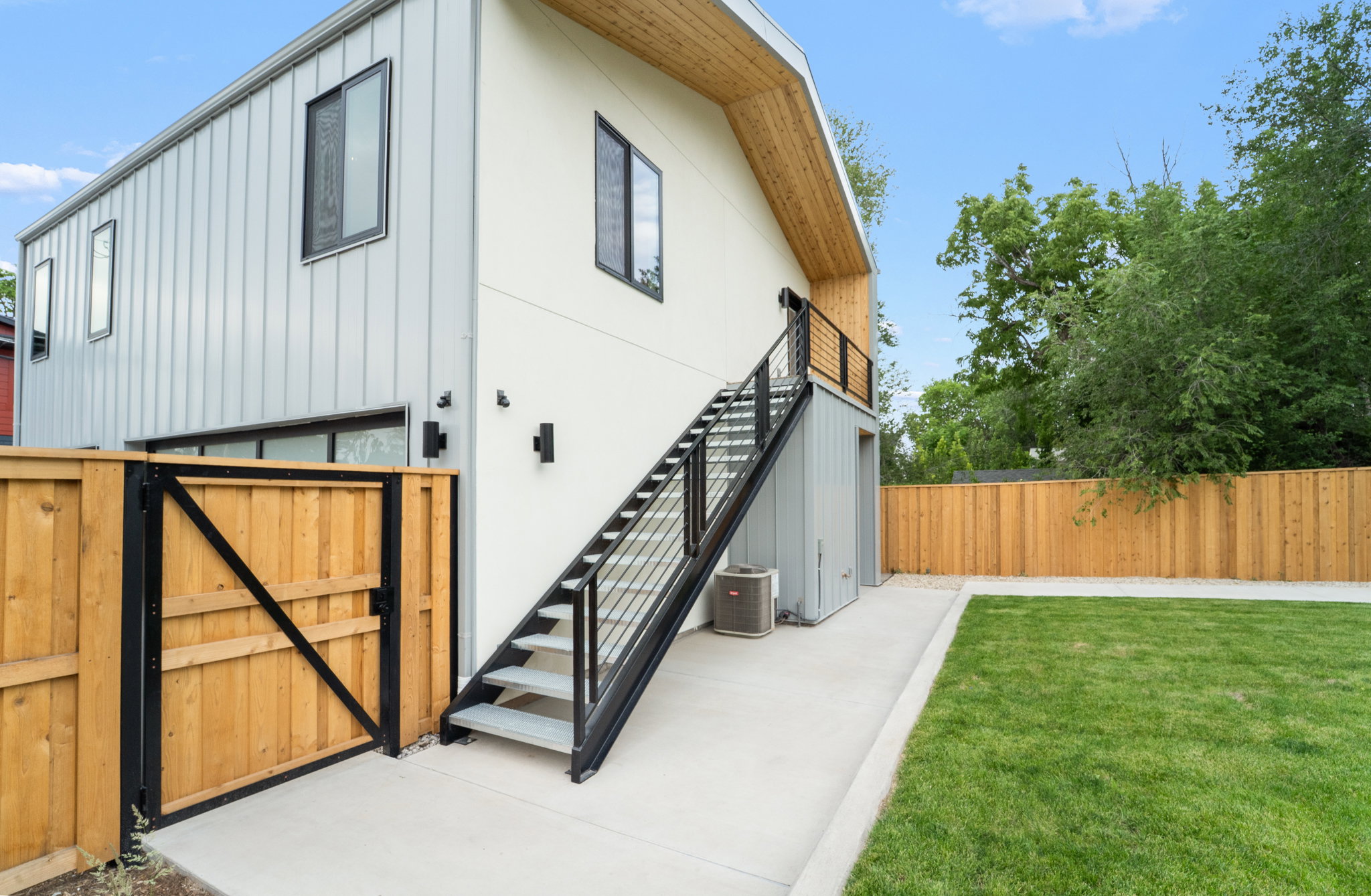 Contemporary architecture featuring vertical metal siding and a light-toned stucco finish