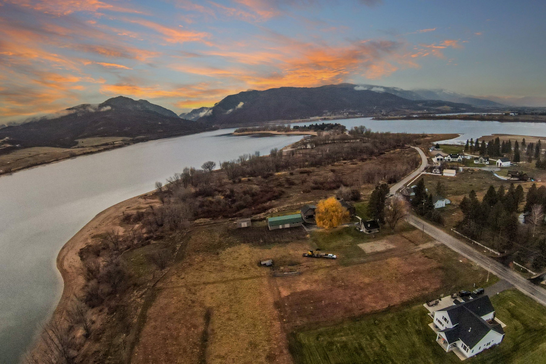 Expansive property with a water frontage, surrounded by distant mountains