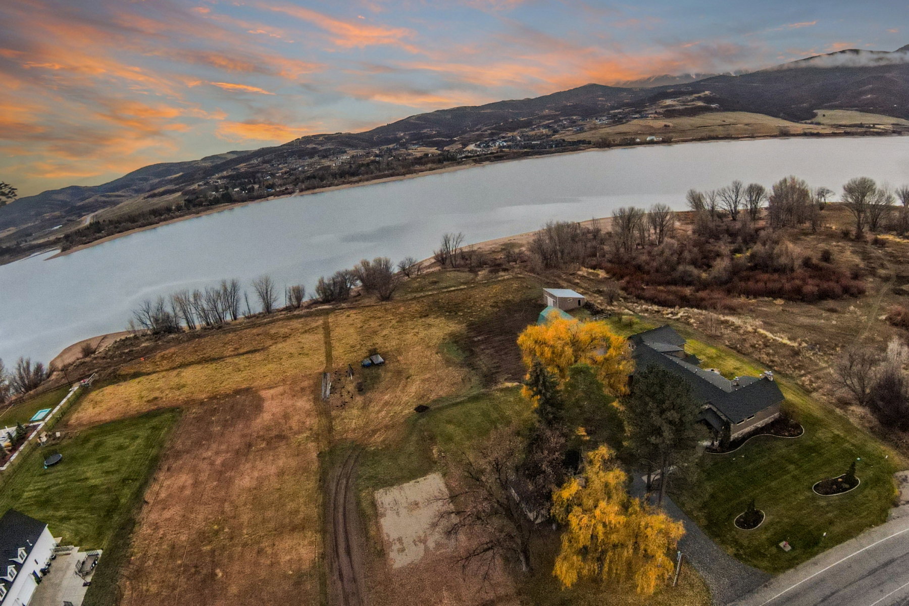 Expansive property featuring a waterfront location, a spacious residence, an additional auxiliary structure, and a paved driveway