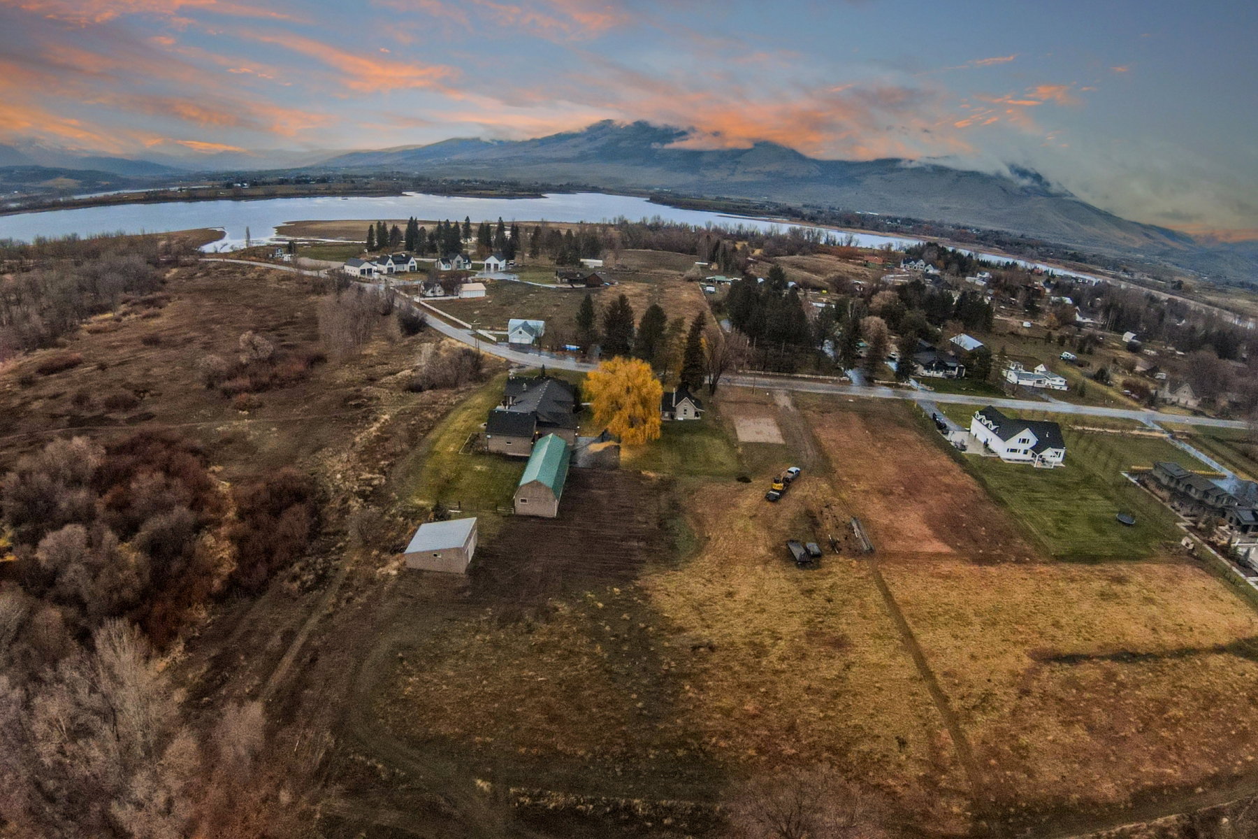 Expansive property featuring multiple structures, open fields, and proximity to a large body of water