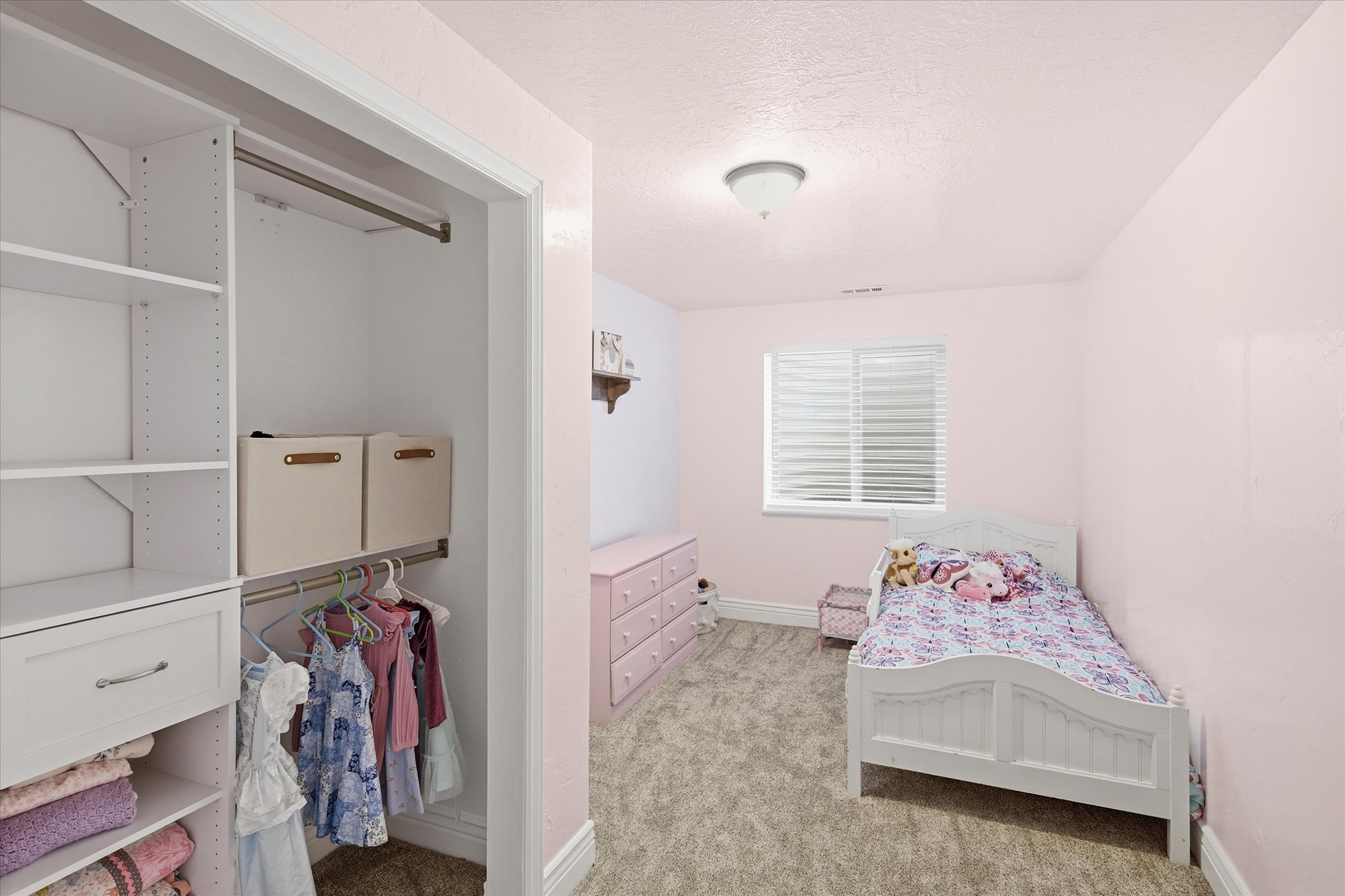 Room featuring soft wall color, a window with blinds, and neutral-toned carpeting