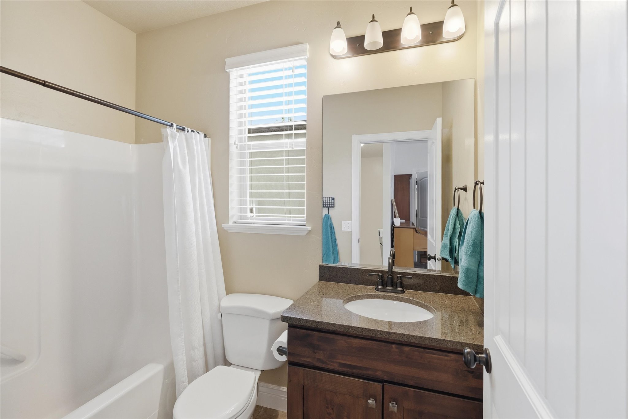 Bathroom featuring a dark wood-finish vanity with an oval undermount sink, a speckle-patterned countertop, and an oil-rubbed bronze faucet