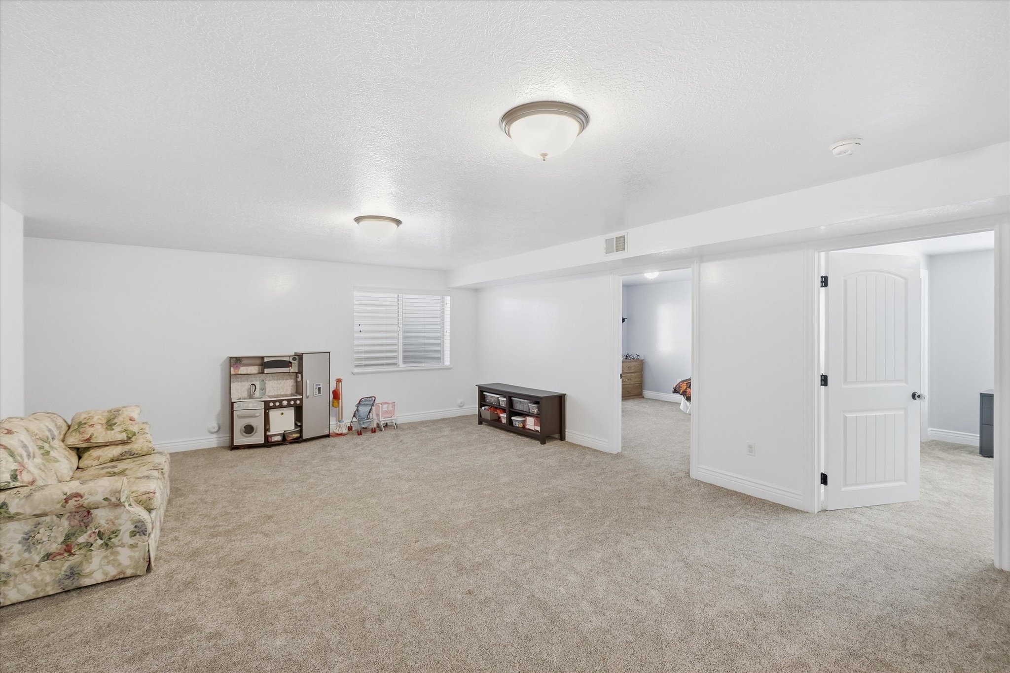 Carpeted interior space featuring white walls and recessed lighting