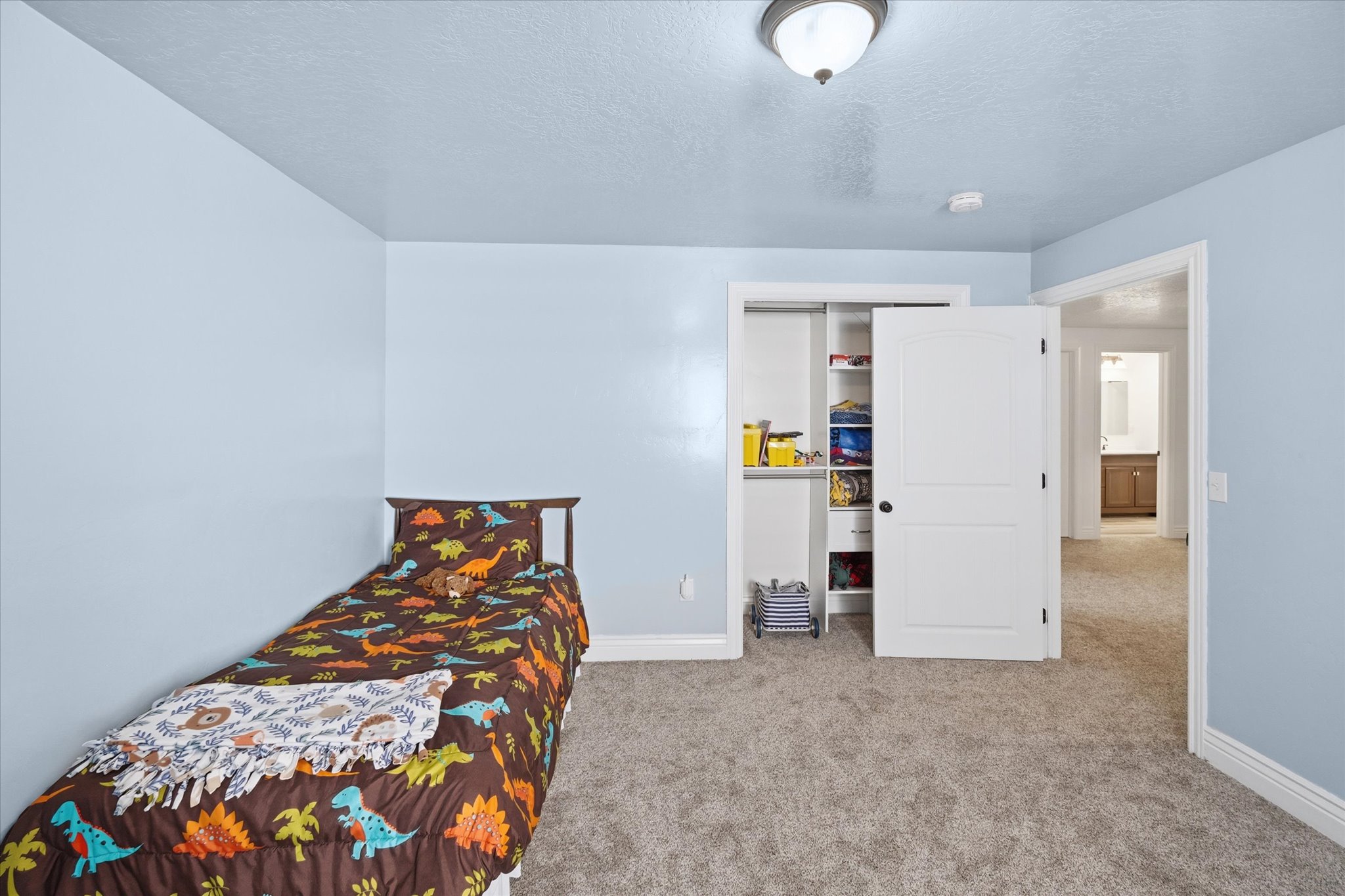 Carpeted interior room featuring light blue walls and white trim