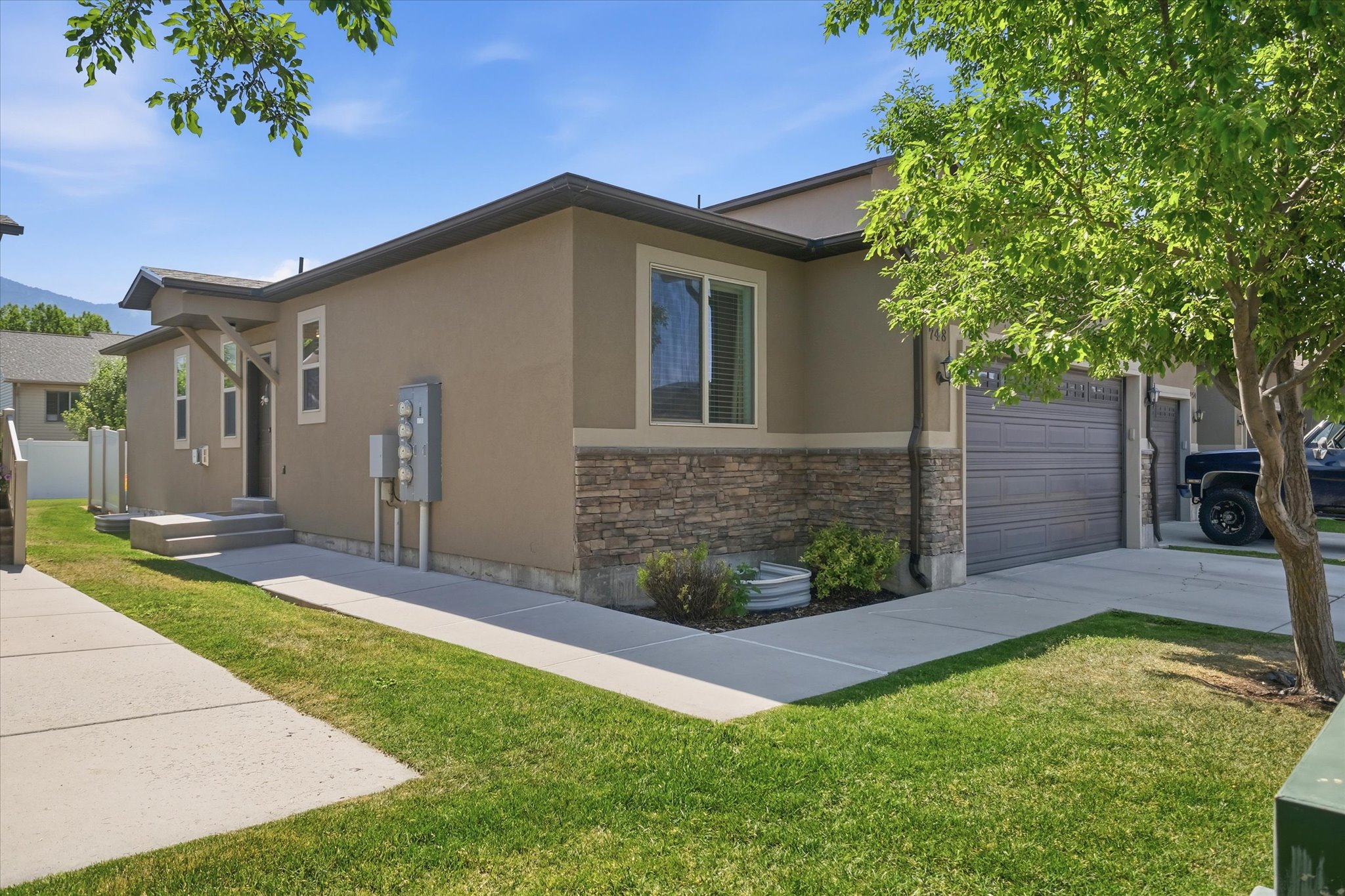 Exterior facade featuring stucco siding with a stone veneer accent