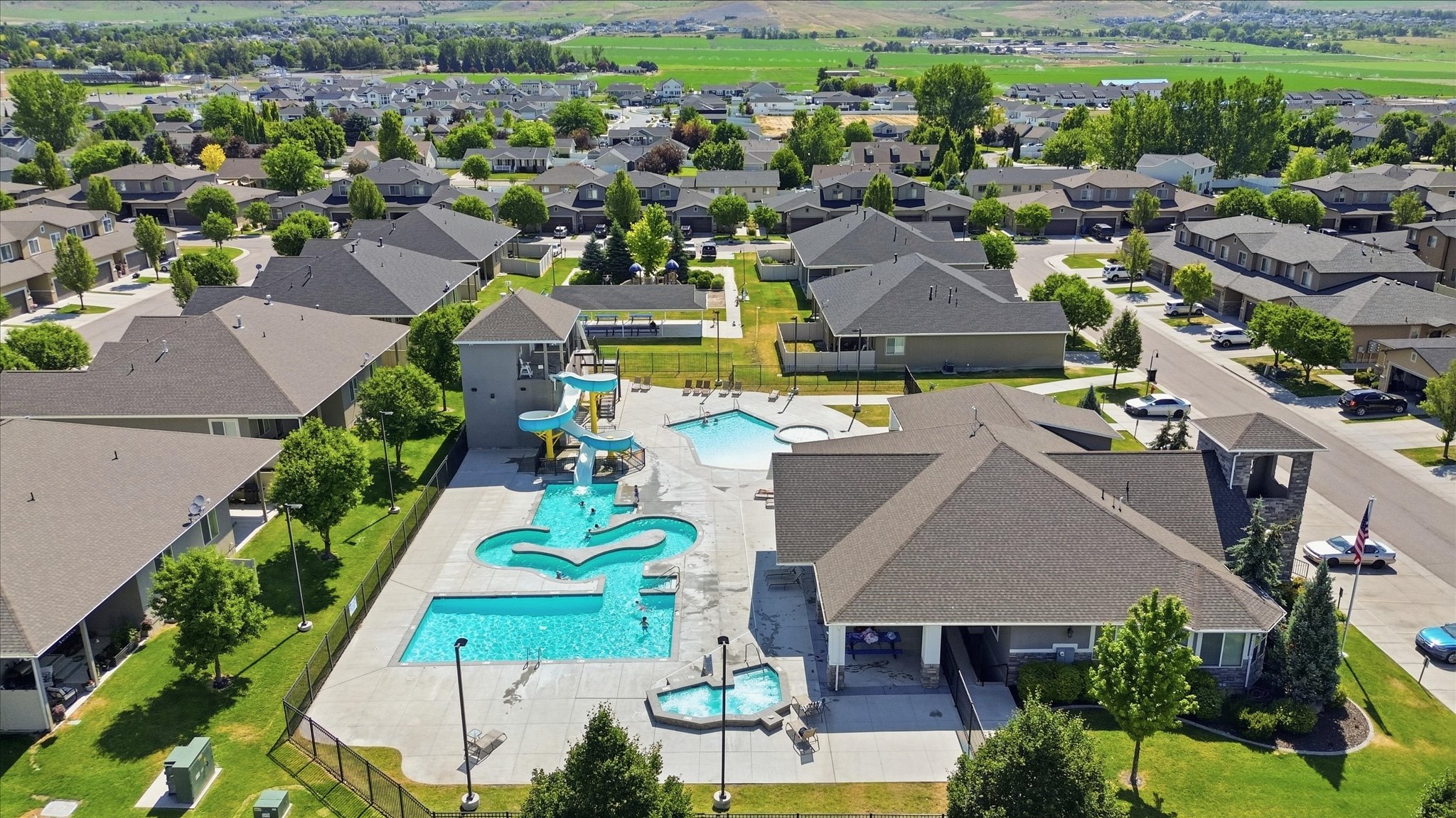 Community pool area featuring multiple swimming pools, a water slide structure, and a separate spa