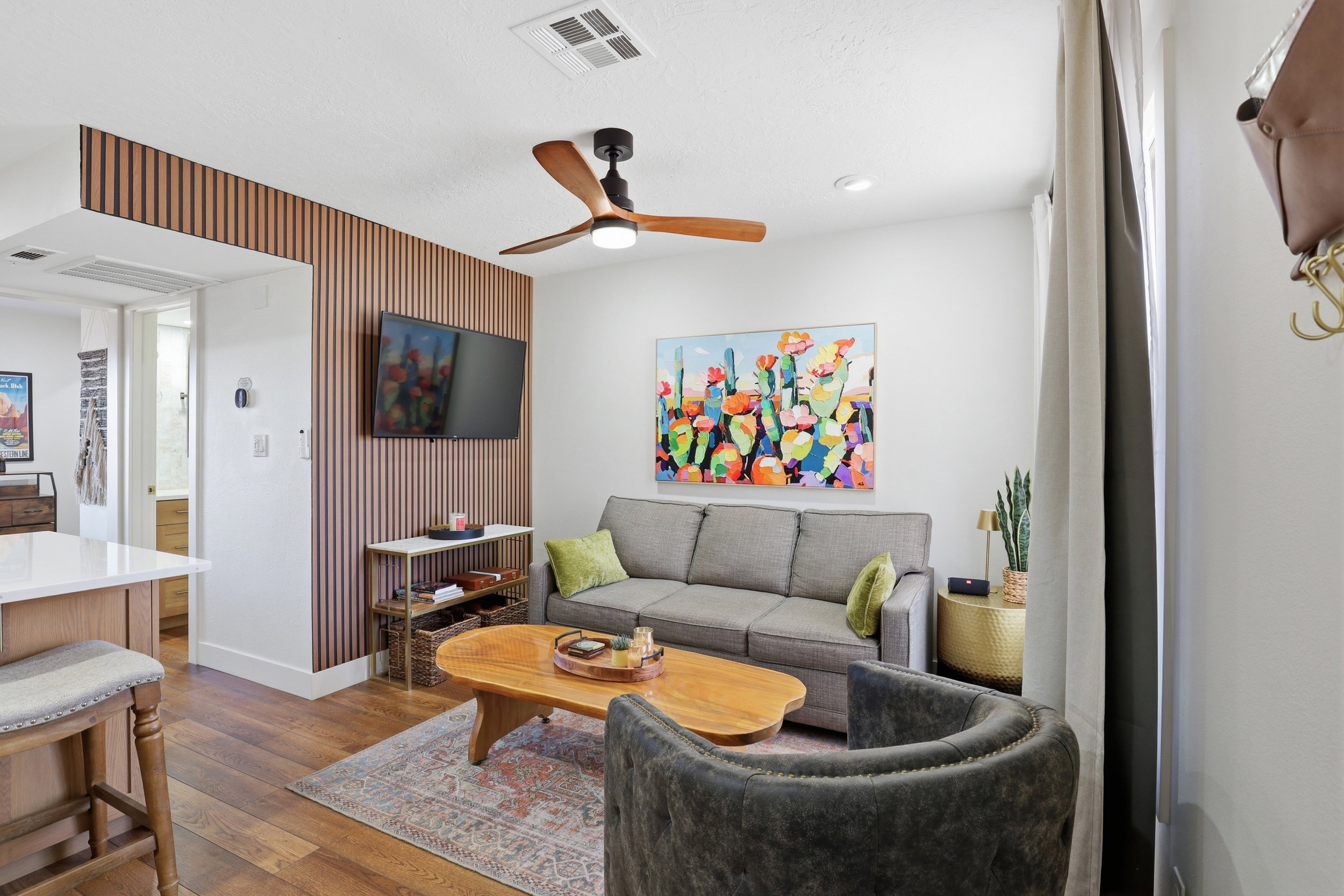 Living area featuring a vertical wood-slat accent wall, wood-finish flooring, recessed lighting, and a ceiling fan