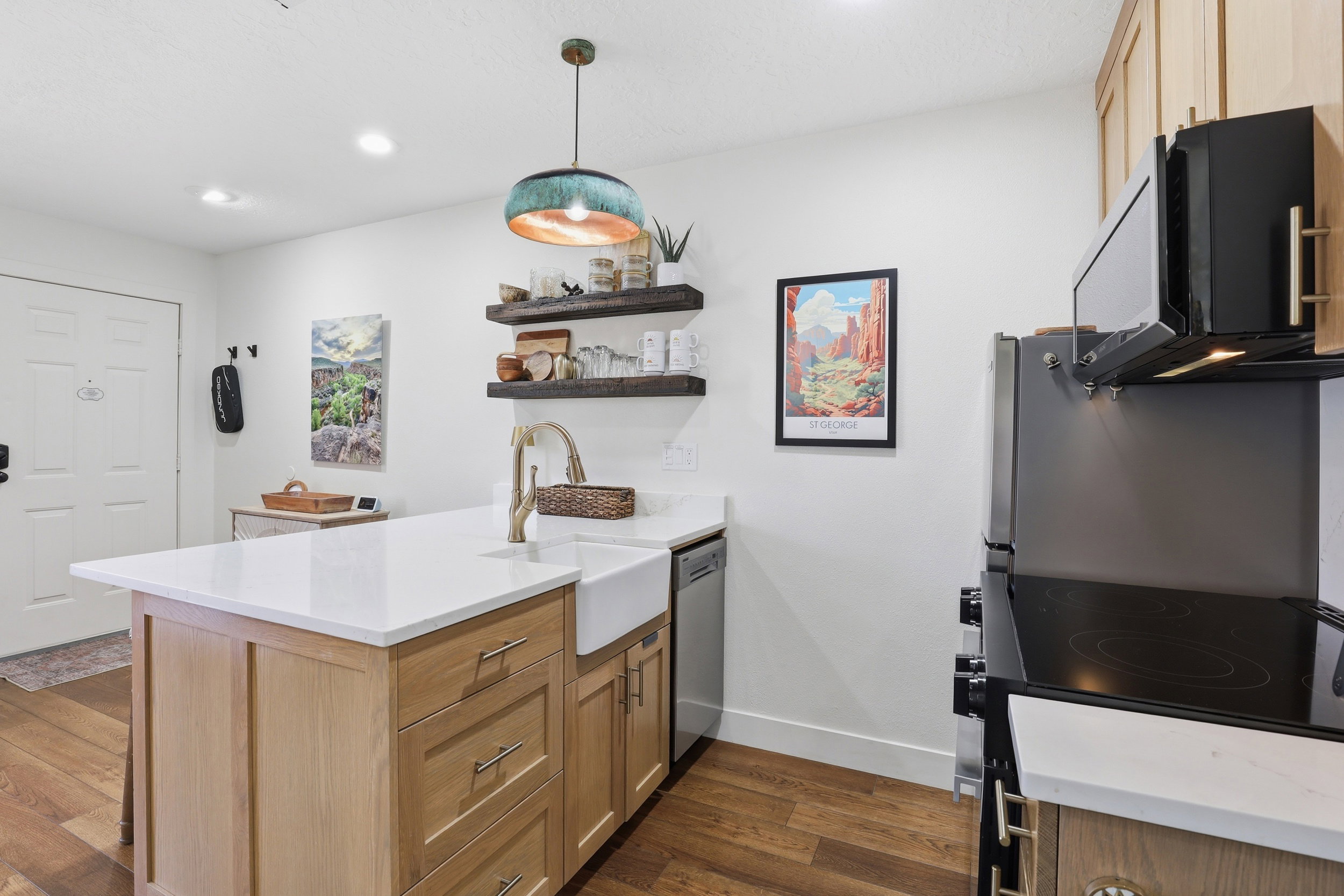 Kitchen island featuring a farmhouse sink, gold-tone faucet, and white countertop