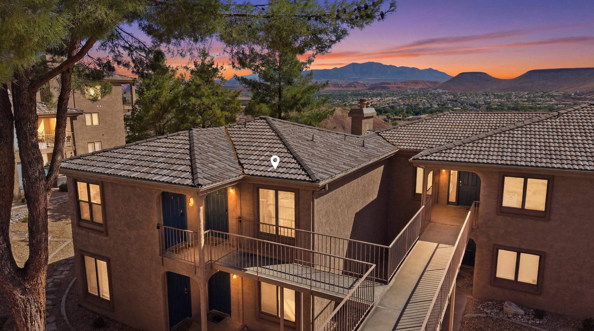 Multi-level building with stucco exterior, tiled roofing, and multiple windows