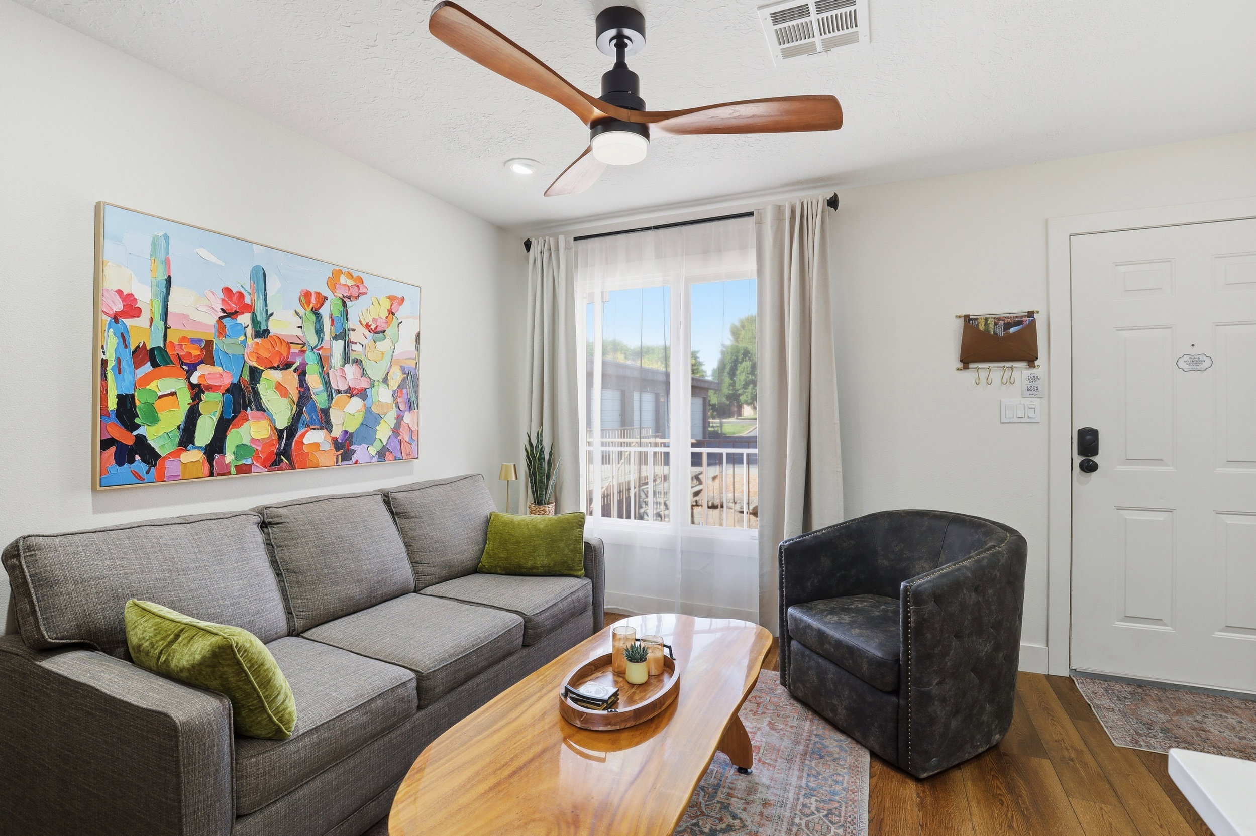 Living area featuring wood-finish flooring, a contemporary ceiling fan, recessed lighting, and a white paneled entry door