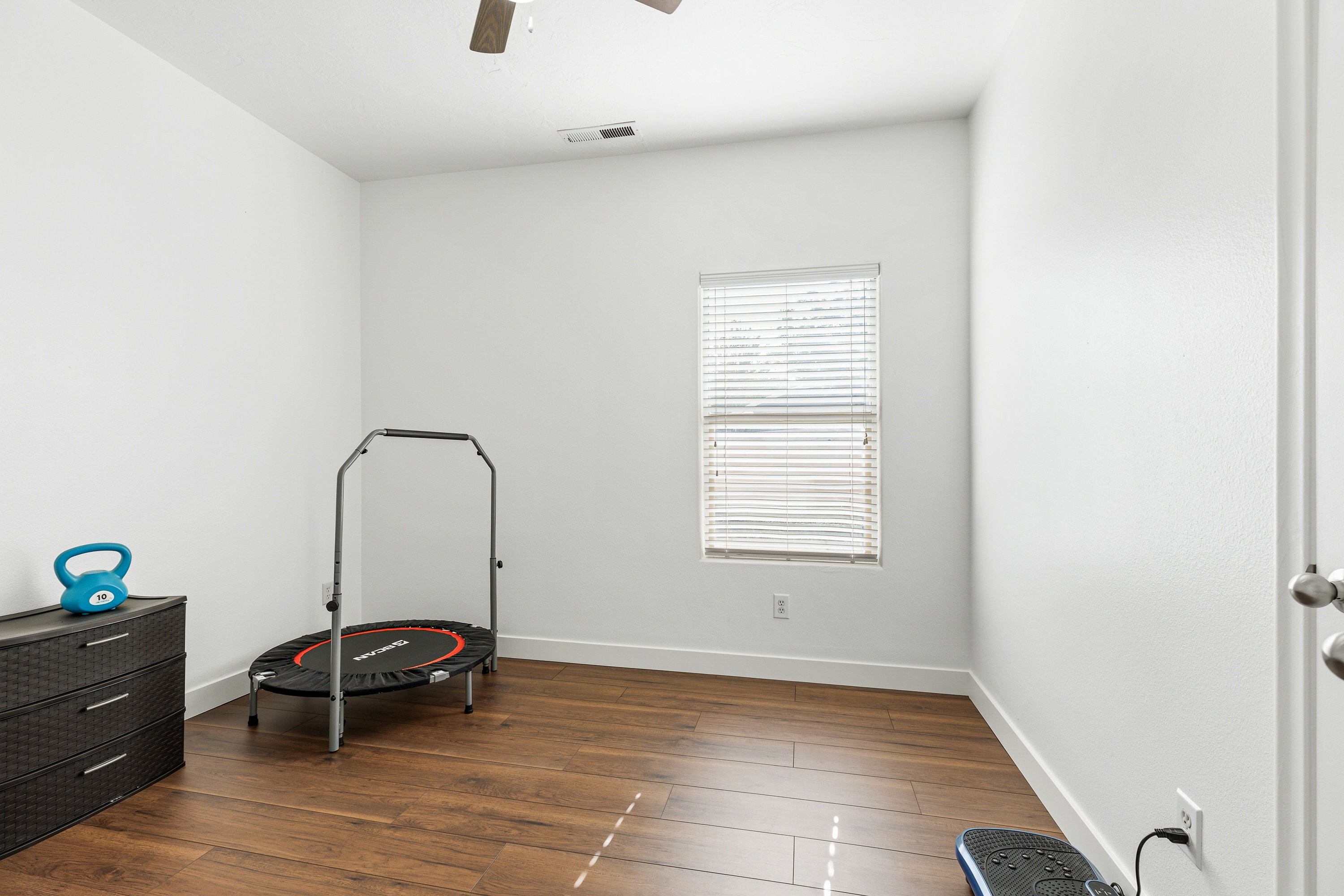 Neutral walls complement wood-finish flooring in this versatile room