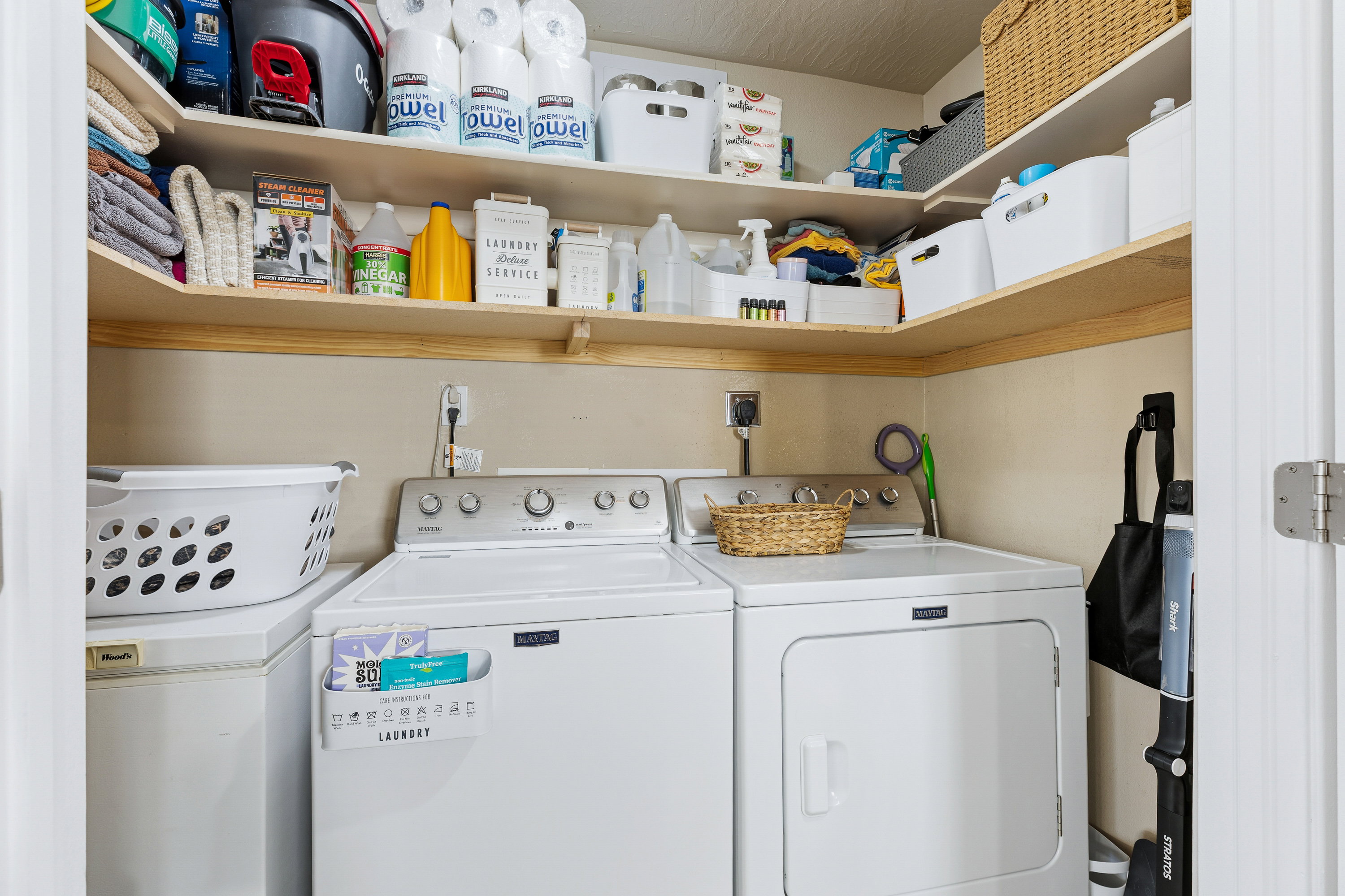 Dedicated laundry space featuring a white top-load washing machine and front-load dryer