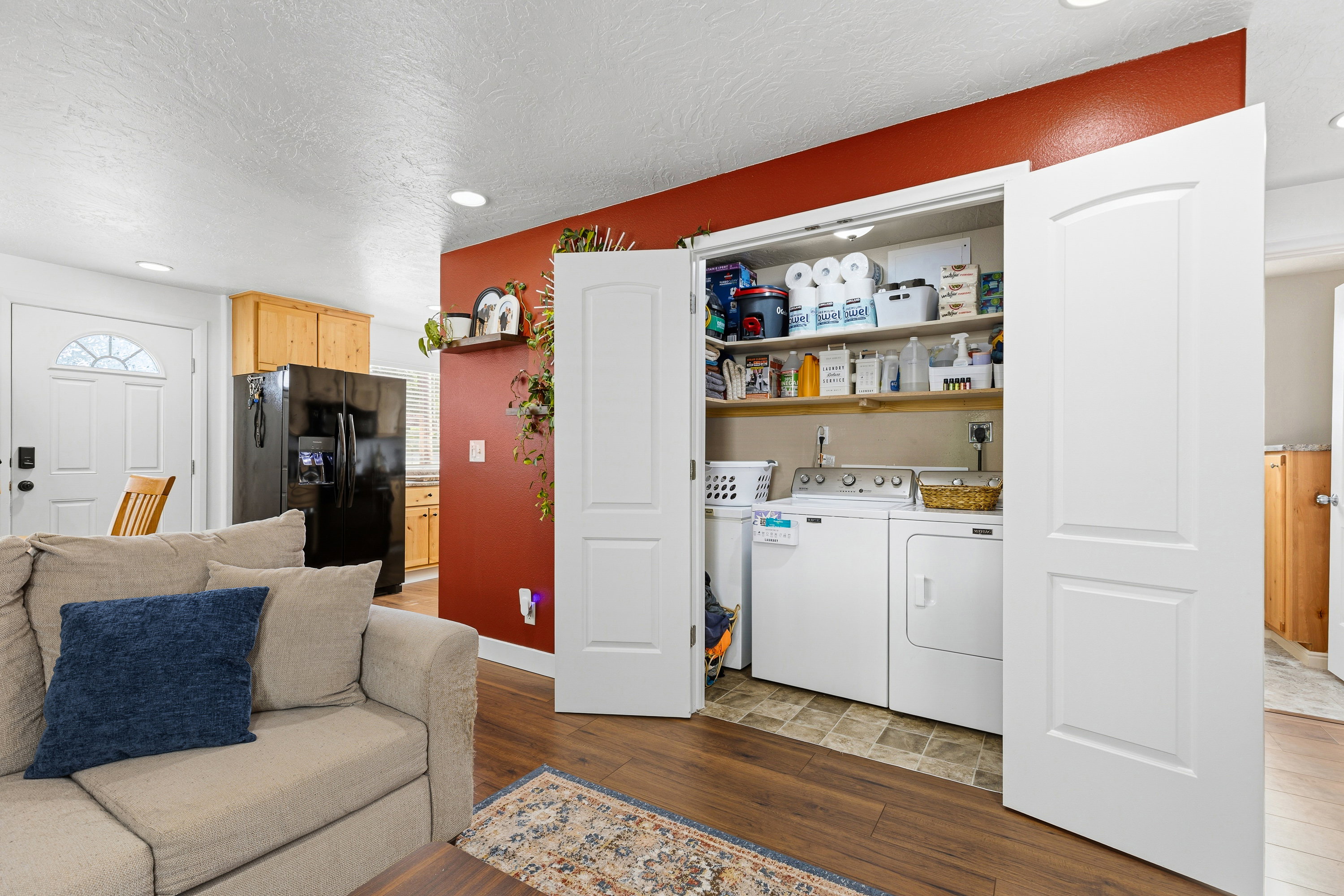 Dedicated laundry closet featuring a washer and dryer, integrated shelving, and tile flooring
