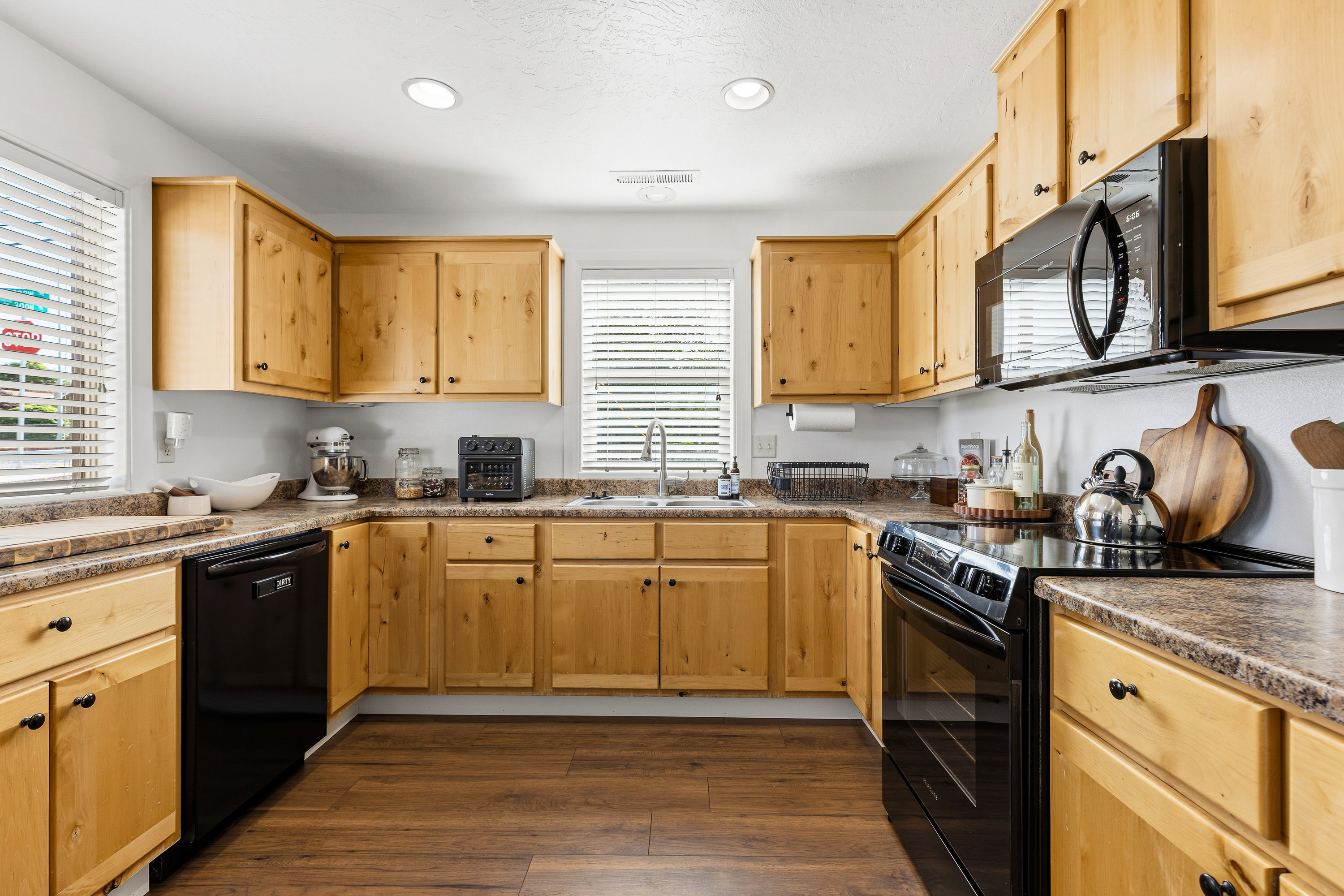 U-shaped kitchen with wood-finish cabinetry and dark countertops