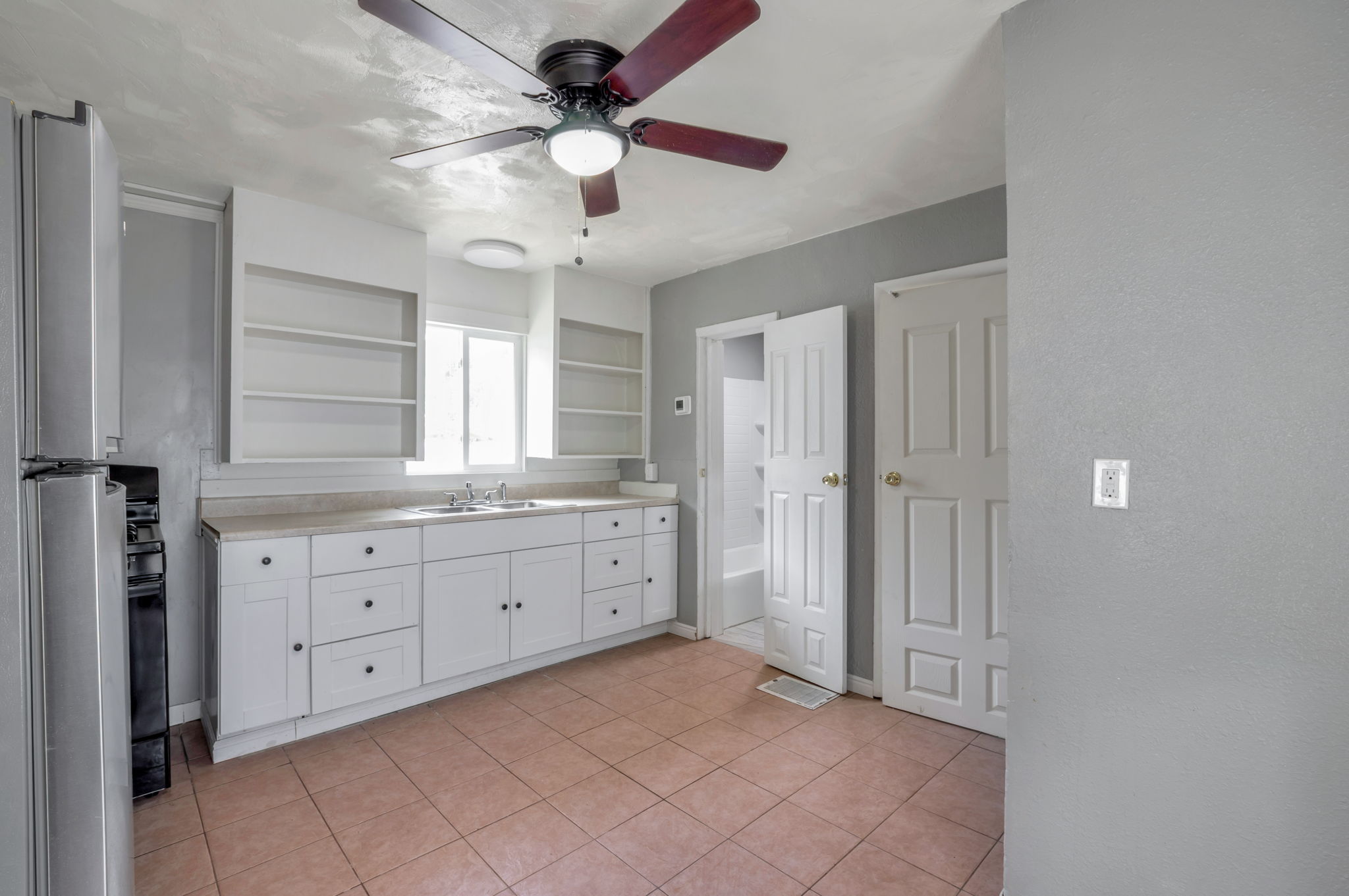 Kitchen featuring white cabinetry, light-toned countertops, and a stainless steel refrigerator