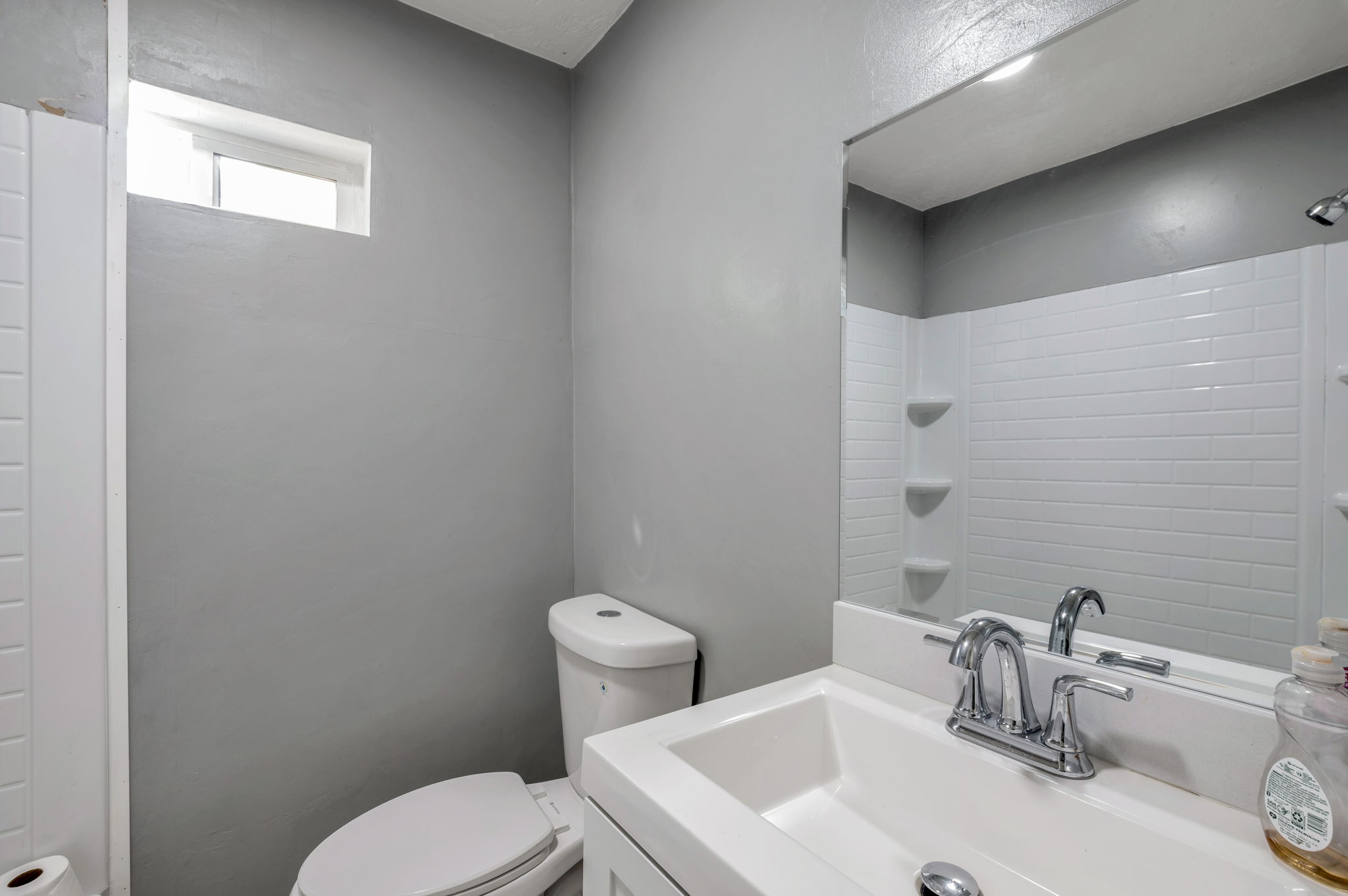 Bathroom featuring a white subway tile shower surround with integrated shelving