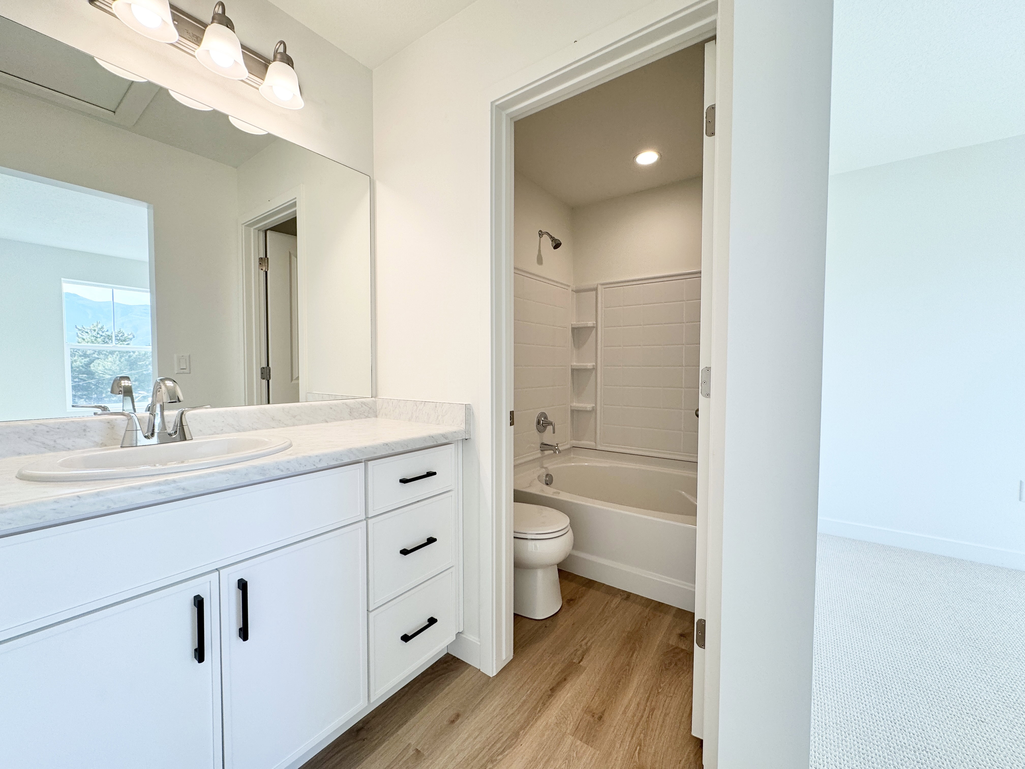 Bathroom featuring a white vanity with a light-colored countertop, an undermount sink, and a large mirror