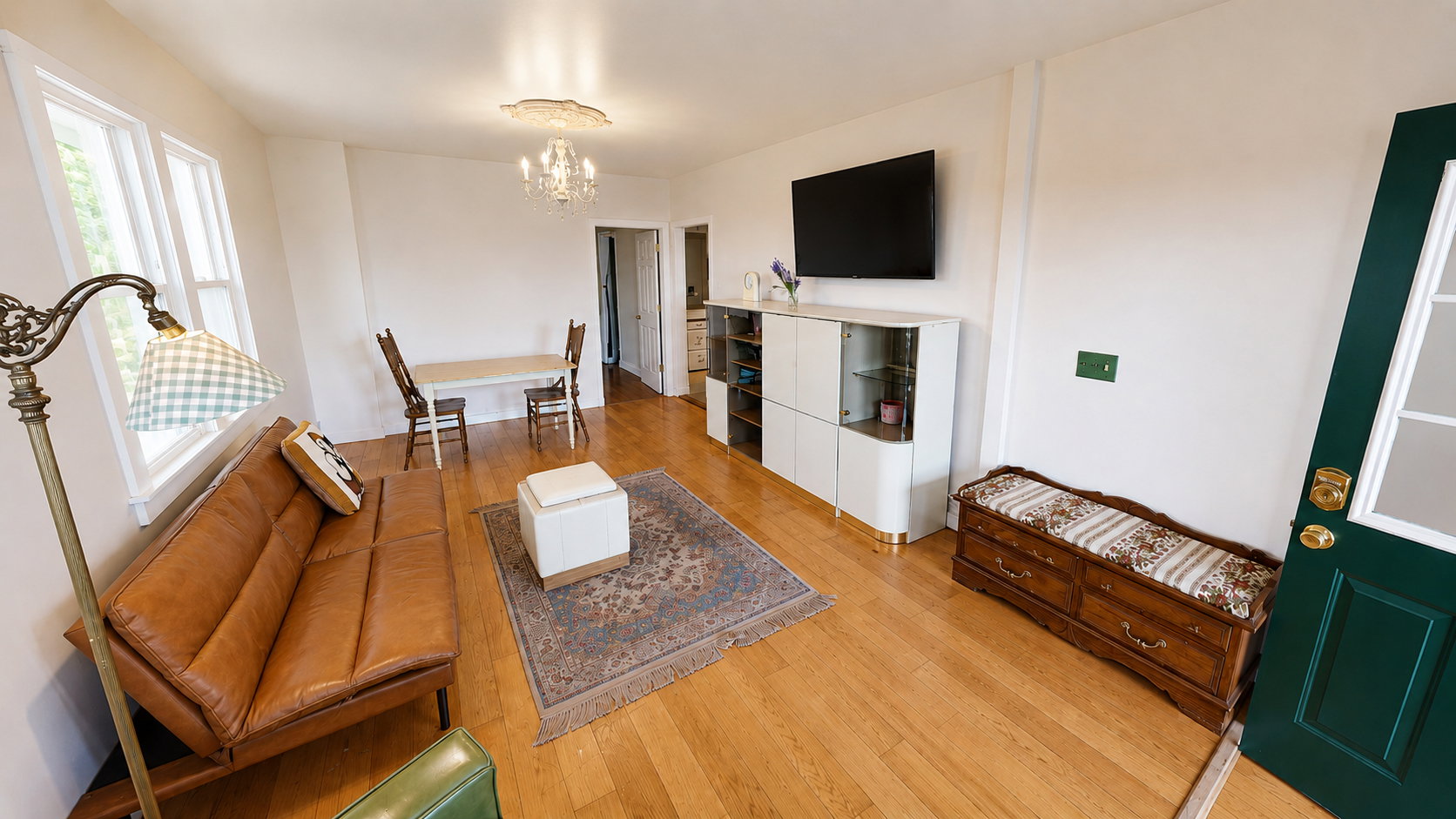 Bright living space featuring wood-finish flooring, white walls, and multiple windows