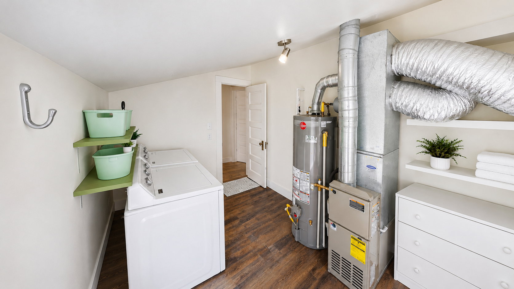 Dedicated laundry area featuring wood-finish flooring, white walls, and built-in shelving