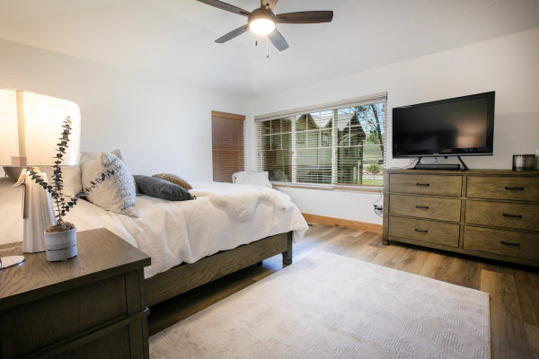 Spacious room featuring wood-like finish flooring and a large window with blinds