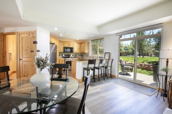 Open-concept kitchen and dining area featuring wood-like finish flooring, recessed lighting, and light wood cabinetry