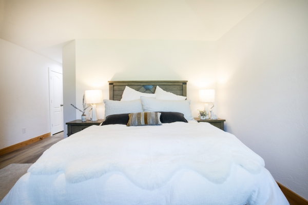 Bedroom featuring light wood-like finish flooring, white painted walls, and a recessed doorway