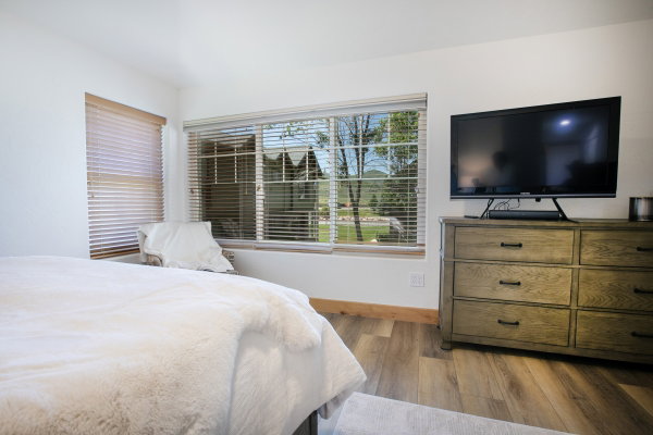 Bright interior space featuring a large window with horizontal blinds and a wood-like finish floor