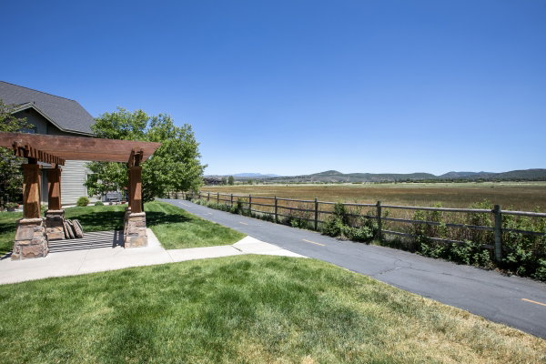 Landscaped yard with a wood pergola featuring stone accents