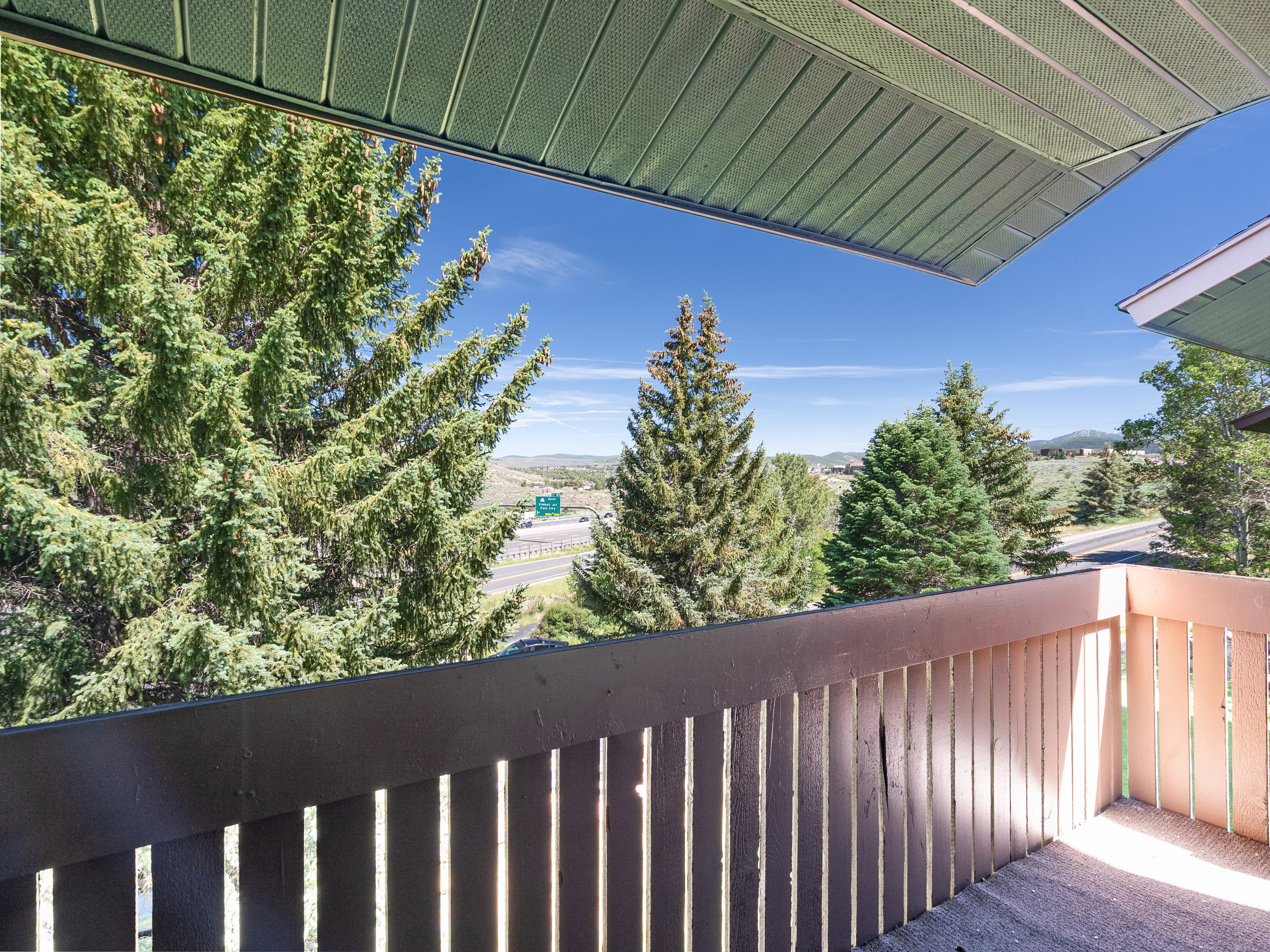 Balcony with light brown painted railing and concrete flooring
