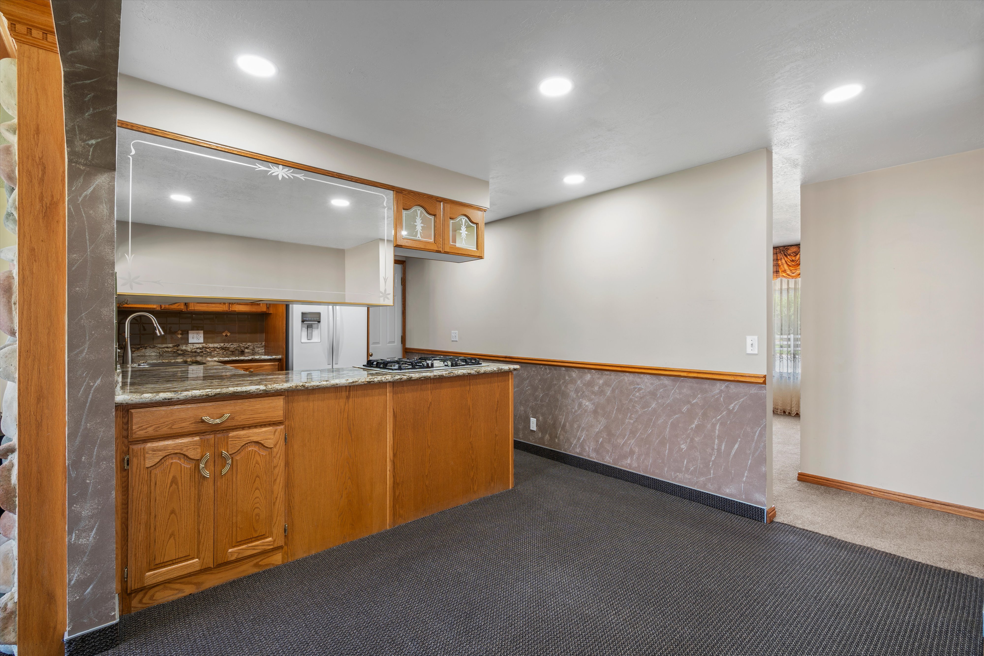 Kitchen area featuring wood cabinetry, a granite-style countertop, and a built-in gas range