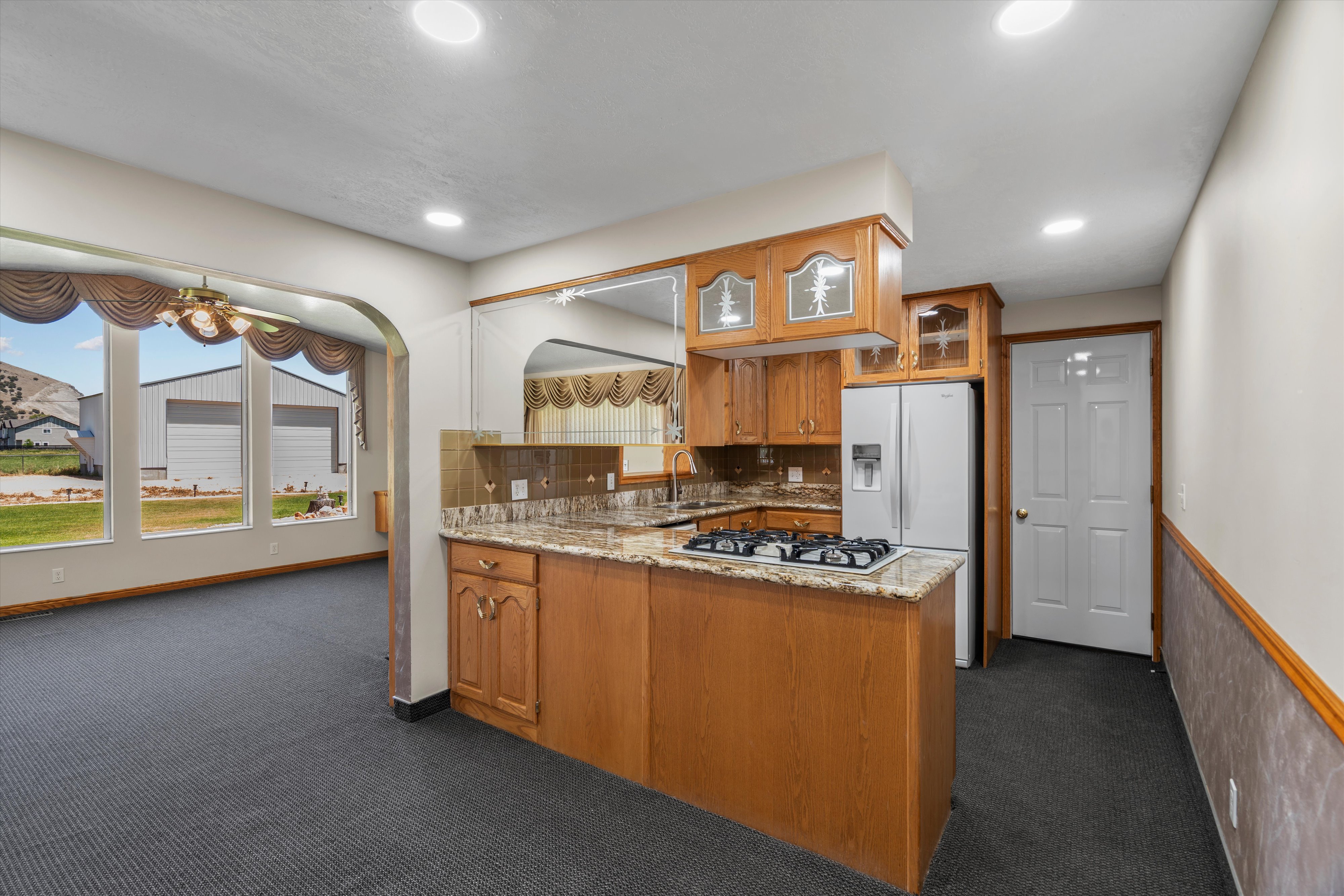 Kitchen featuring wood cabinetry, granite-finish countertops, and a built-in gas cooktop