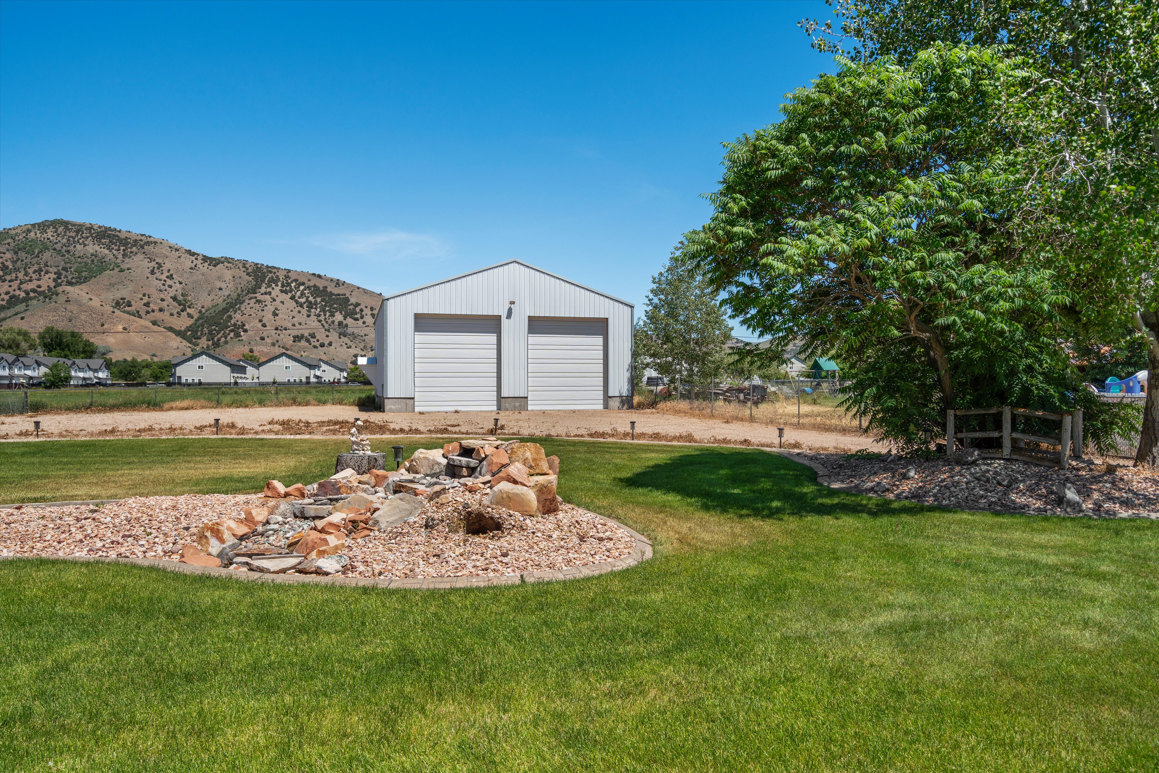 Expansive green lawn with a decorative rock garden water feature