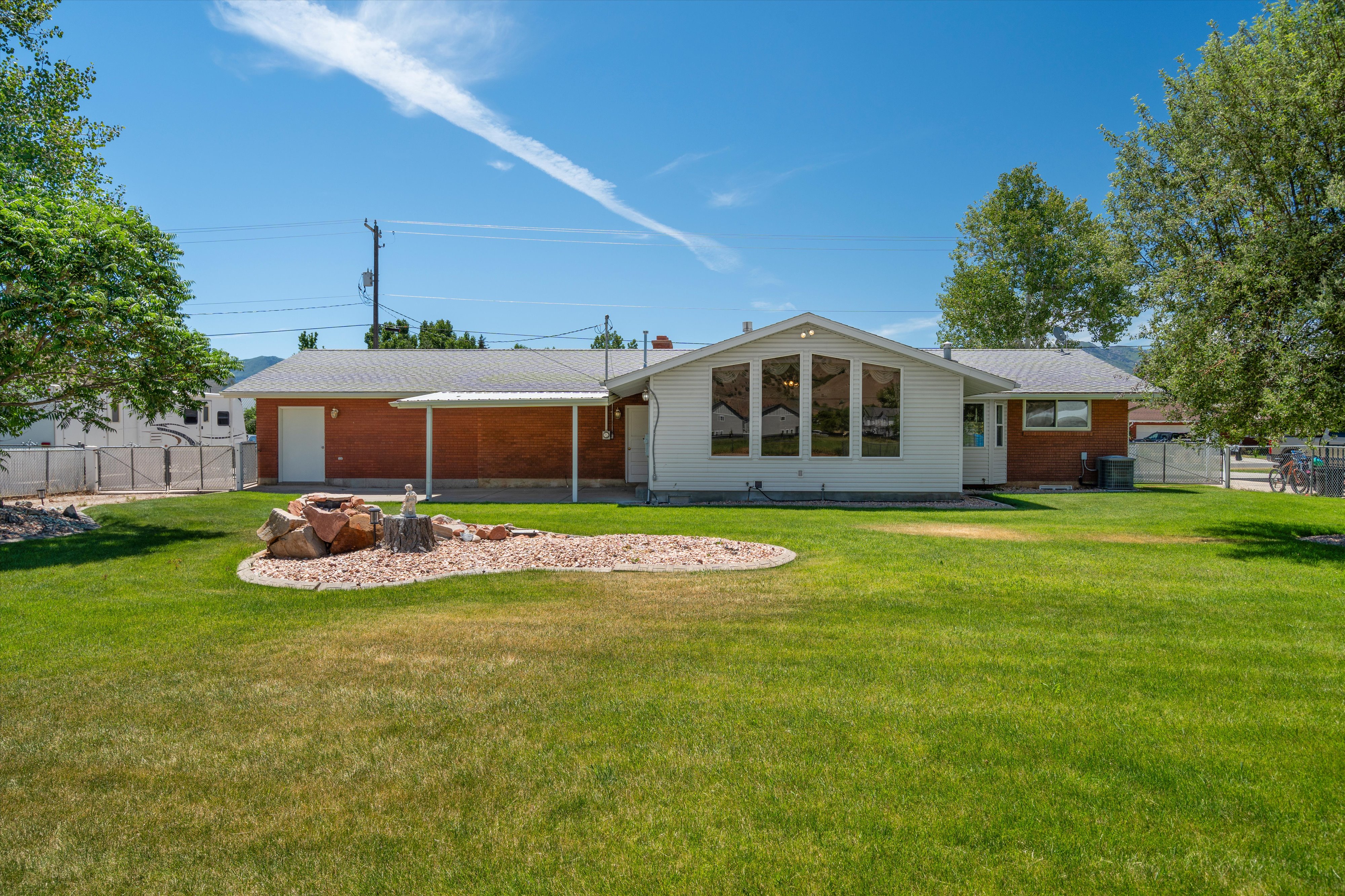 Expansive green lawn with a rock-lined garden feature