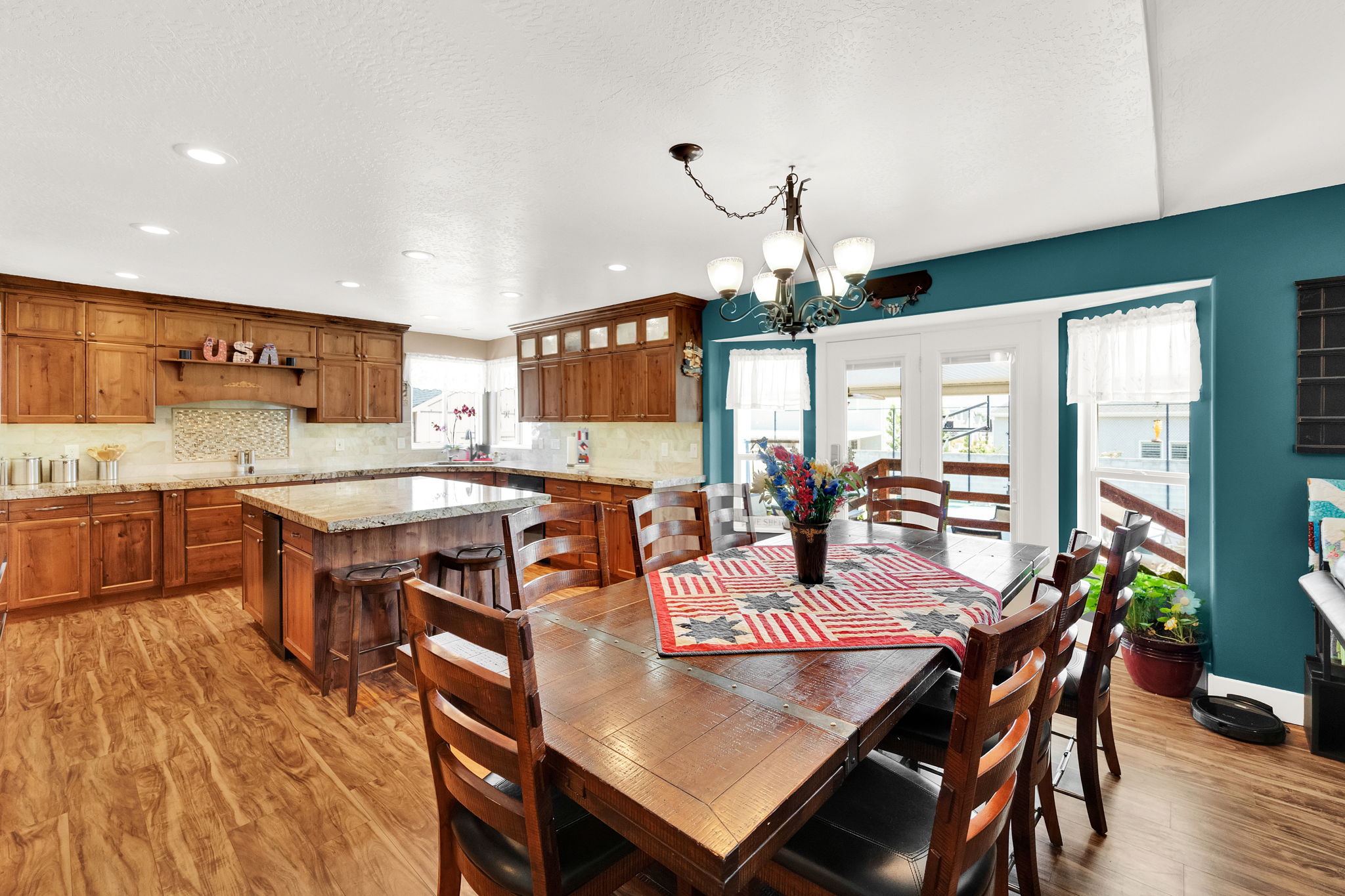 Kitchen and dining area featuring wood-finish flooring, recessed lighting, and a vaulted ceiling