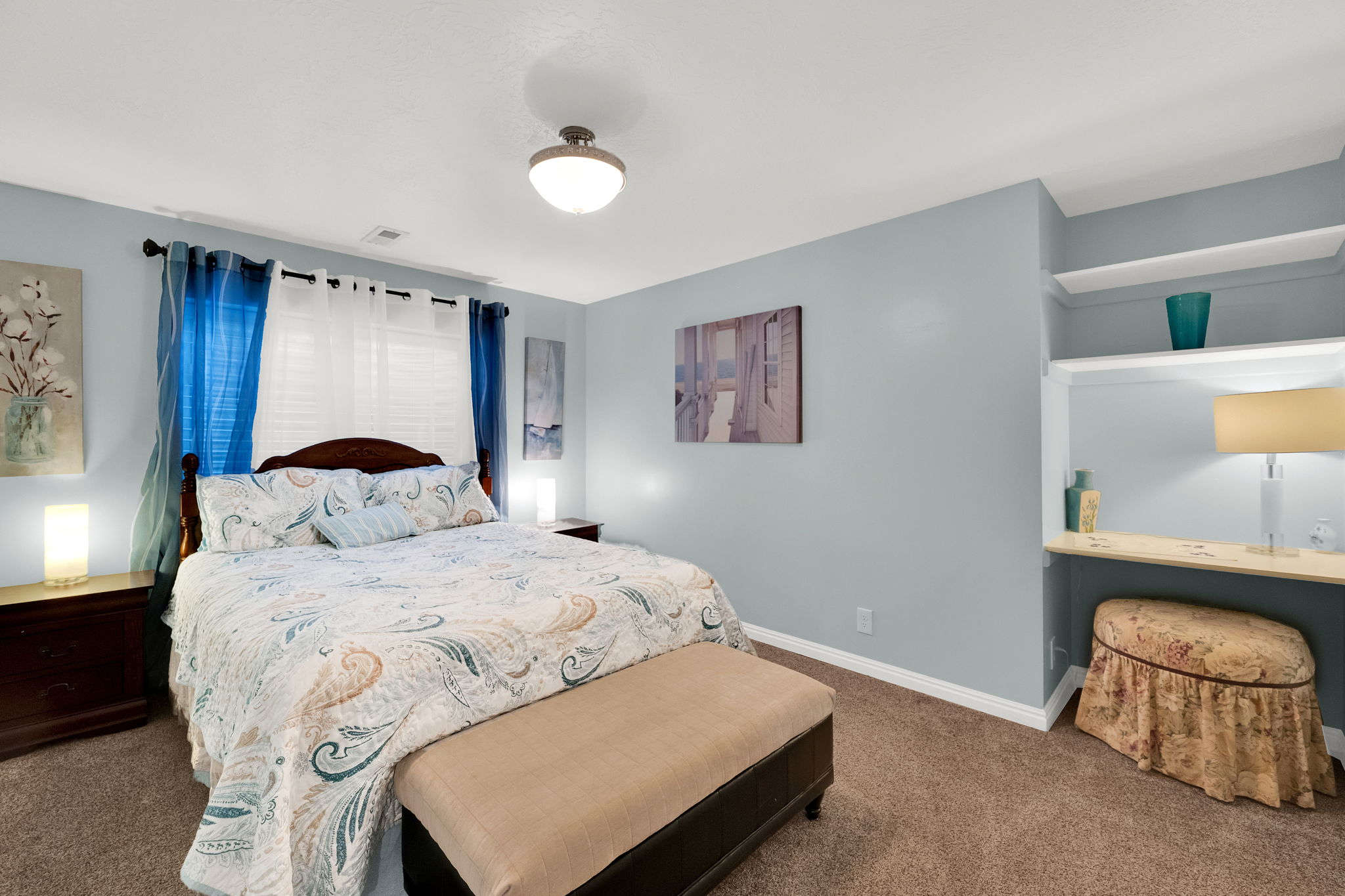 Bedroom featuring a built-in vanity nook with shelving, wood-finish flooring, and a flush-mount ceiling light