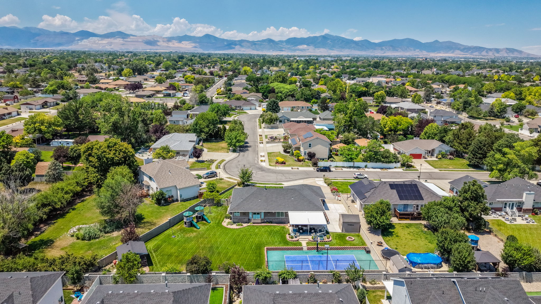 Expansive residential area featuring a dedicated sports court, above-ground pool, and covered patio